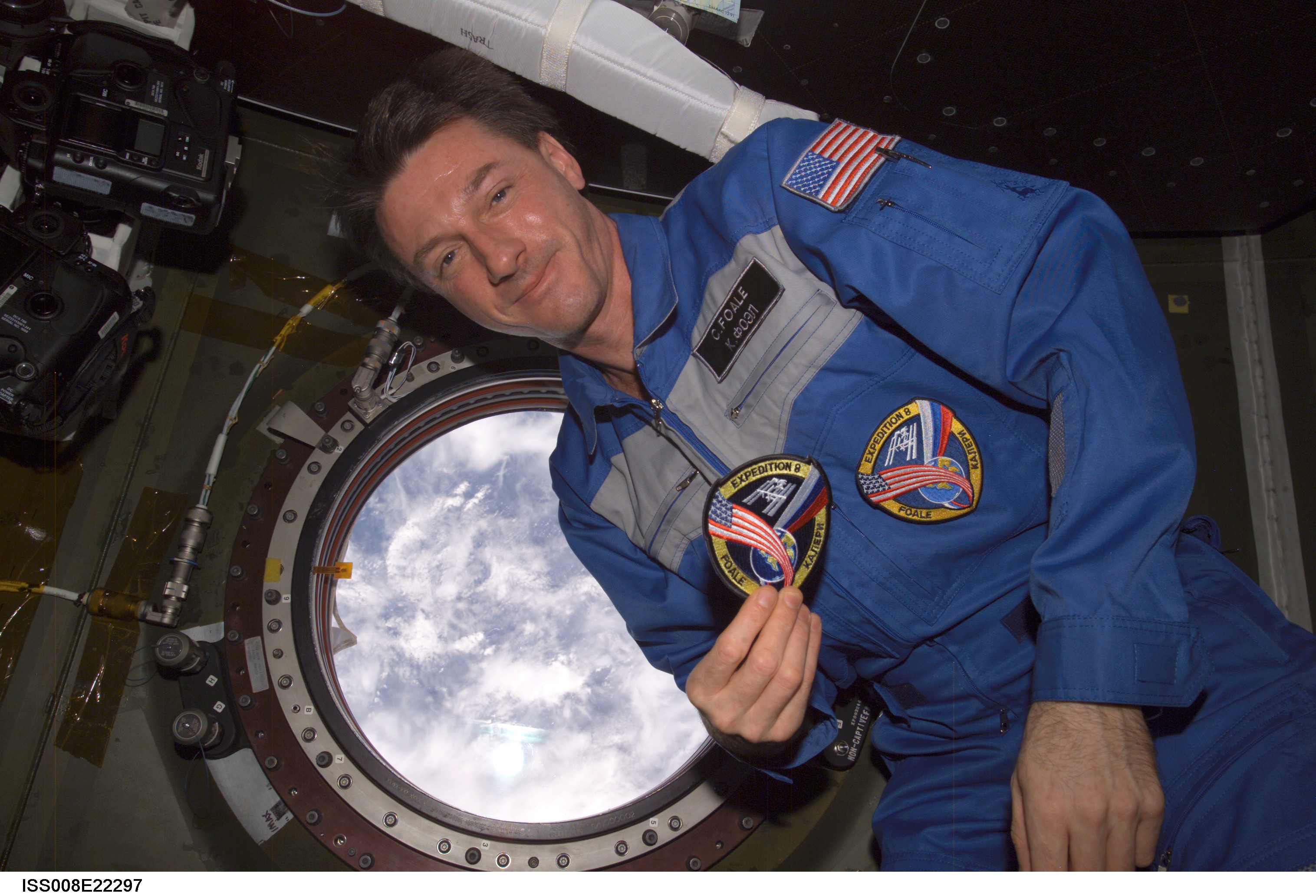Foale, holding EXP 8 patch, poses beside science window in the U.S. Lab