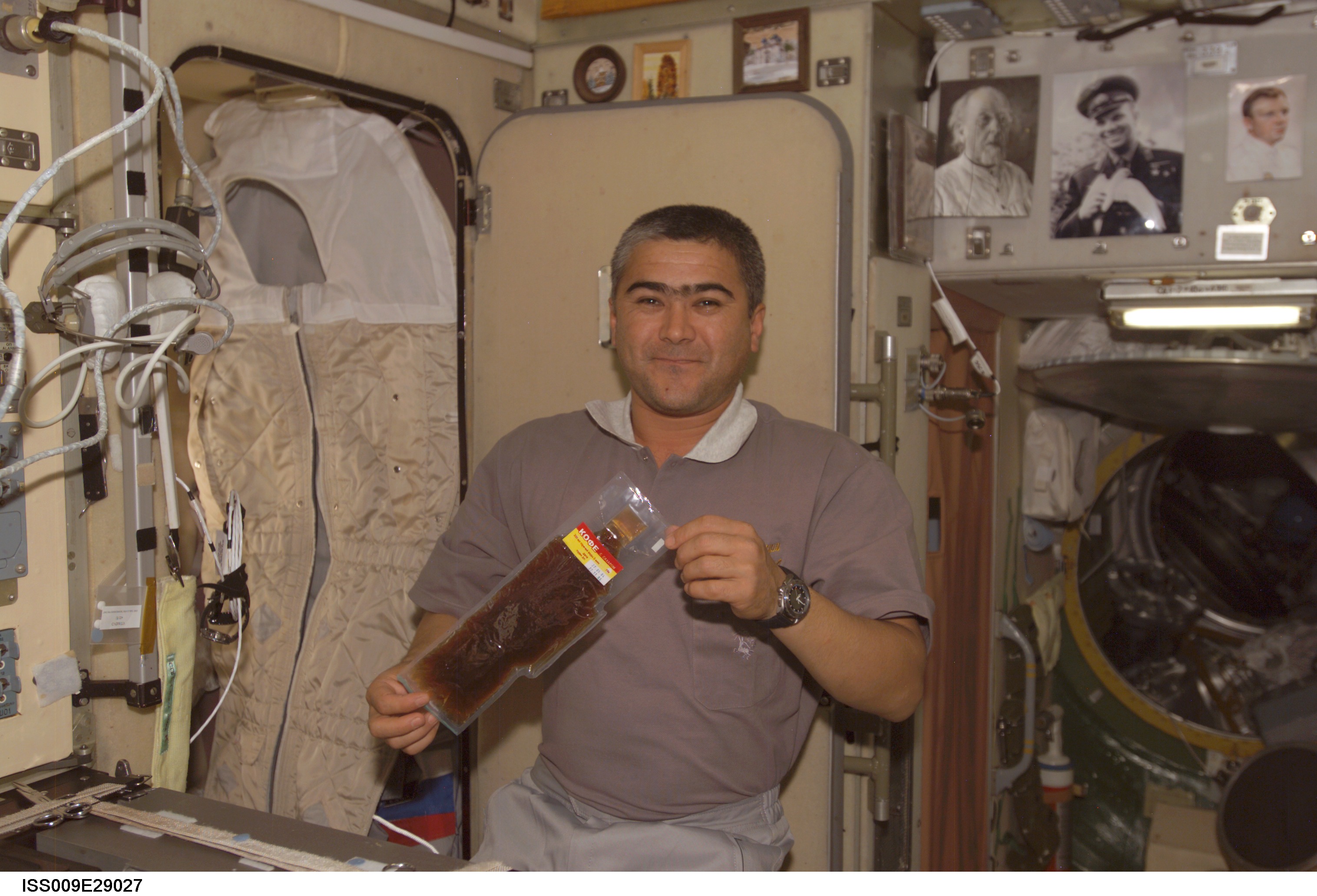 Sharipov holds a package of Russian food near the galley in the SM during Expedition 9/10 joint OPS
