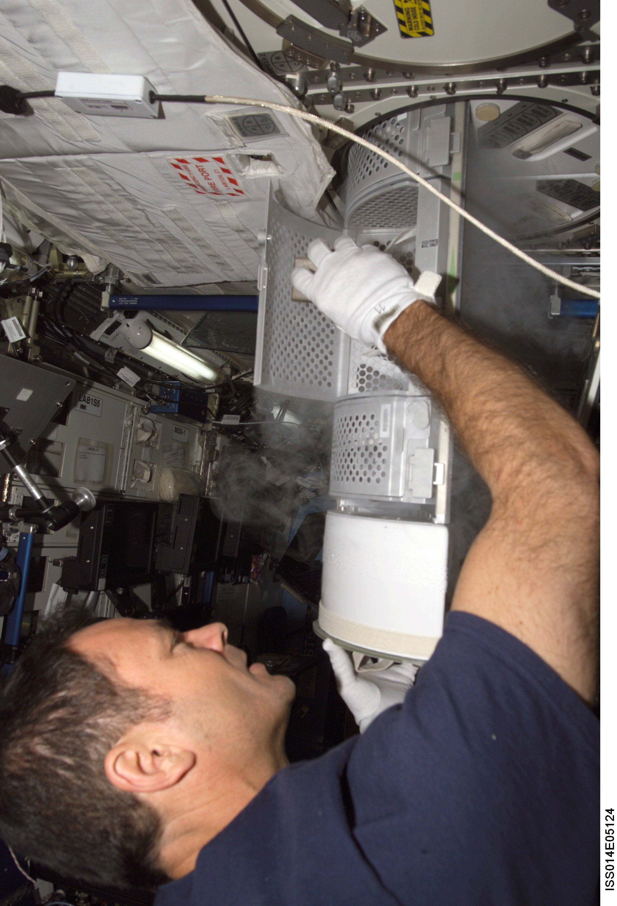 Lopez-Alegria with Passive Observatories for Experimental Microbial Systems in Micro-G (POEMS) sample container