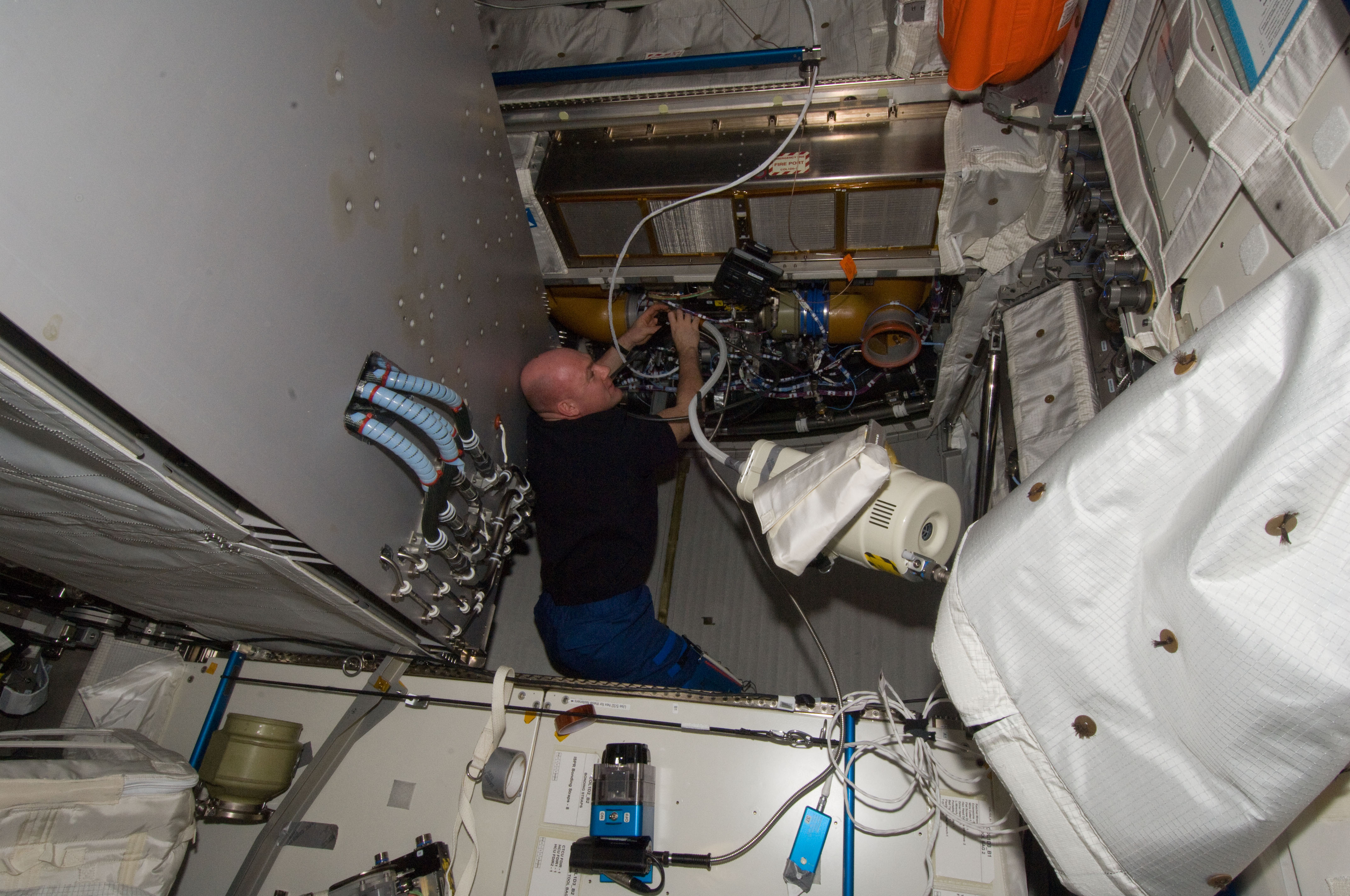 Kuipers uses vacuum cleaner while performing maintenance in the Columbus Module