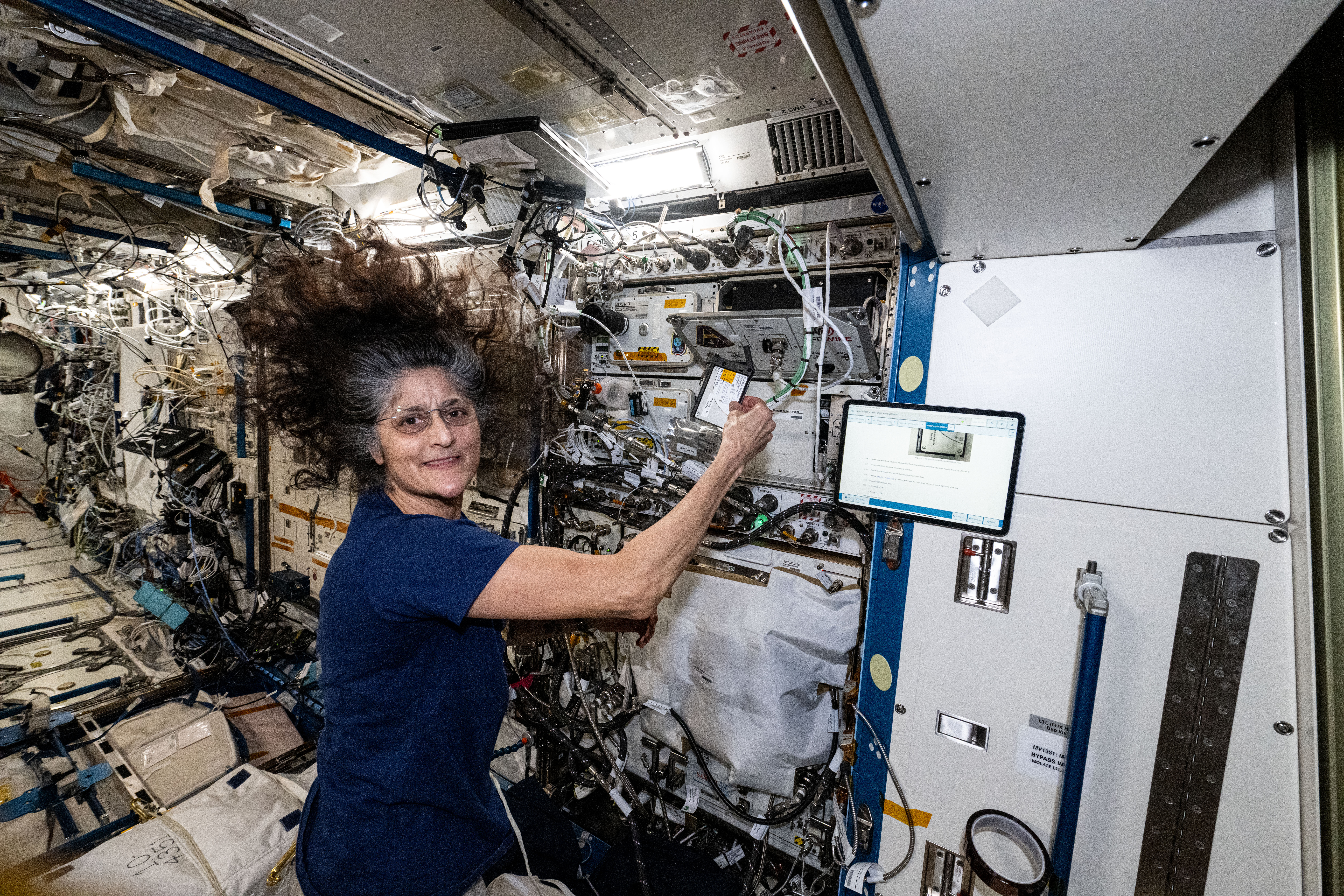 Astronaut Suni Williams swaps a hard drive inside a sample processor