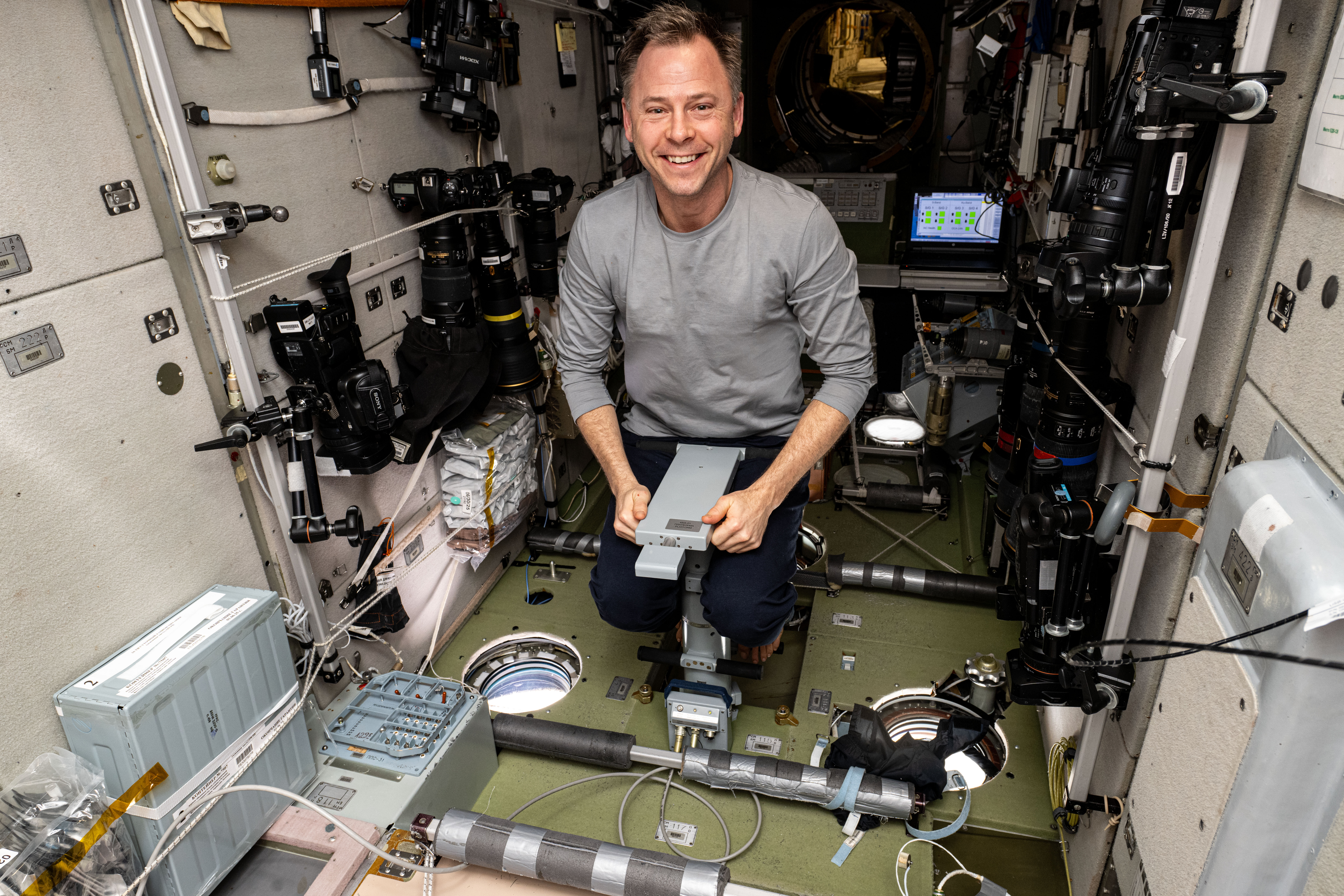 Astronaut Nick Hague measures his mass using a specialized device