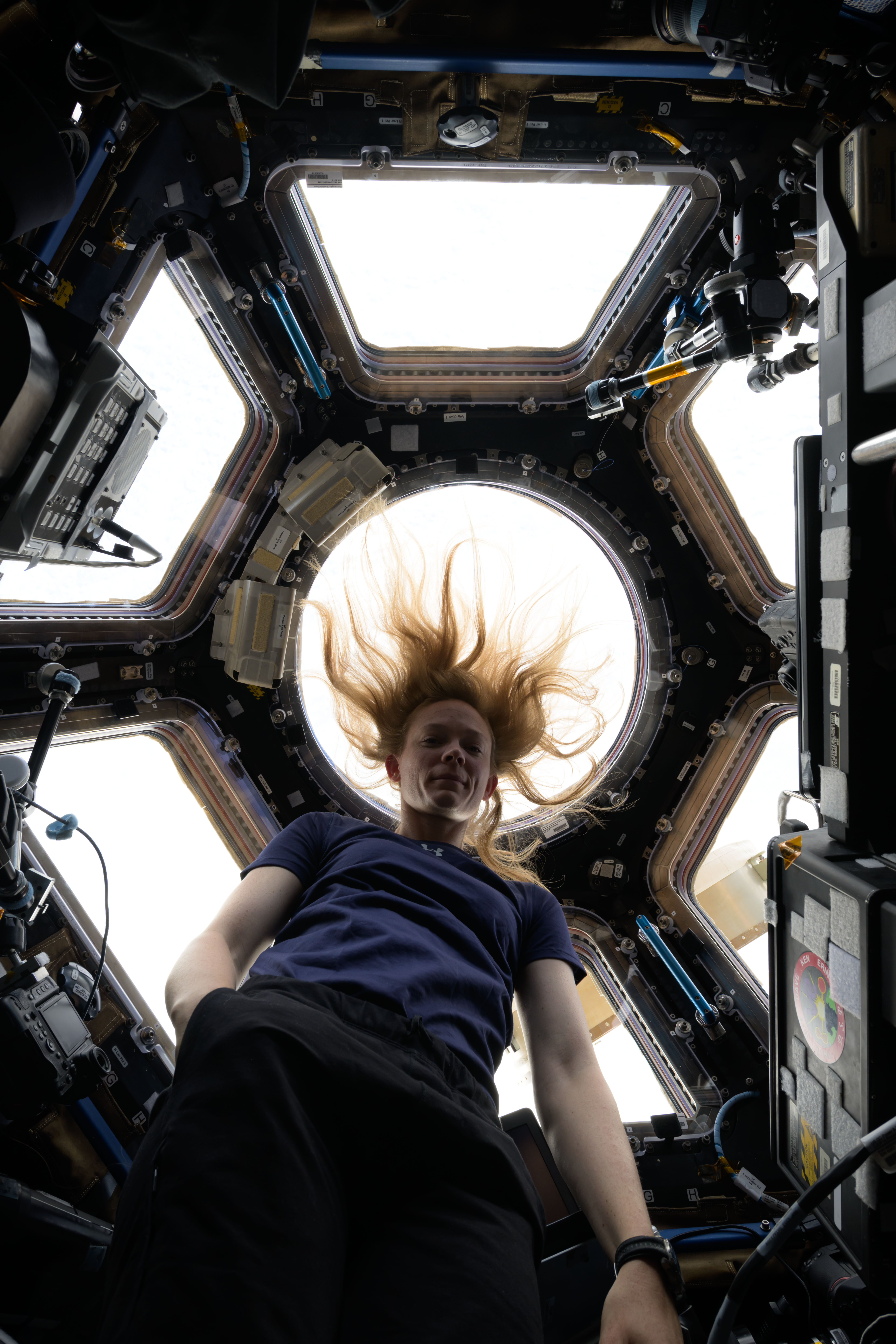 Astronaut Nichole Ayers poses for a portrait inside the seven window cupola