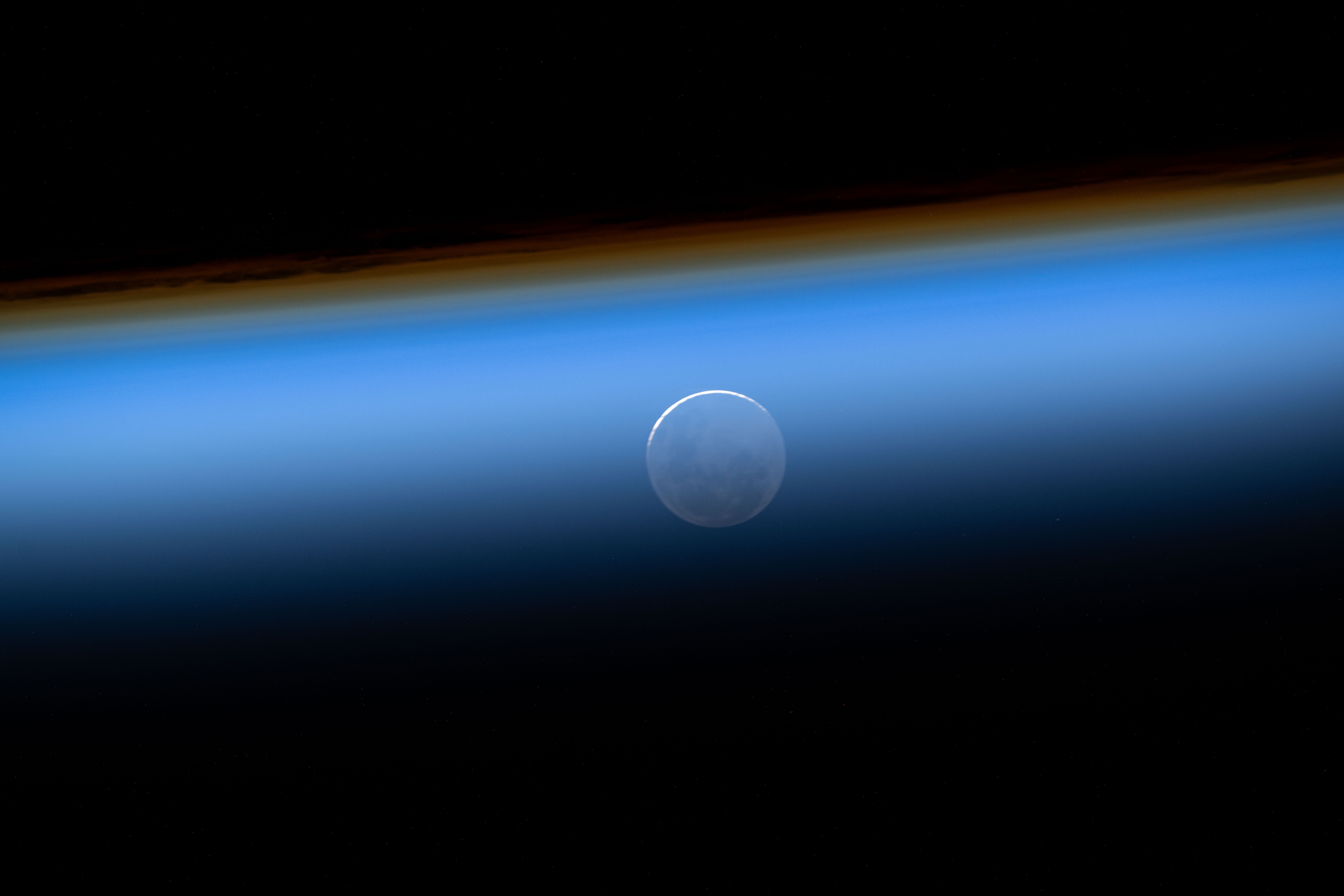 The New Moon is pictured seemingly beneath Earth's atmosphere