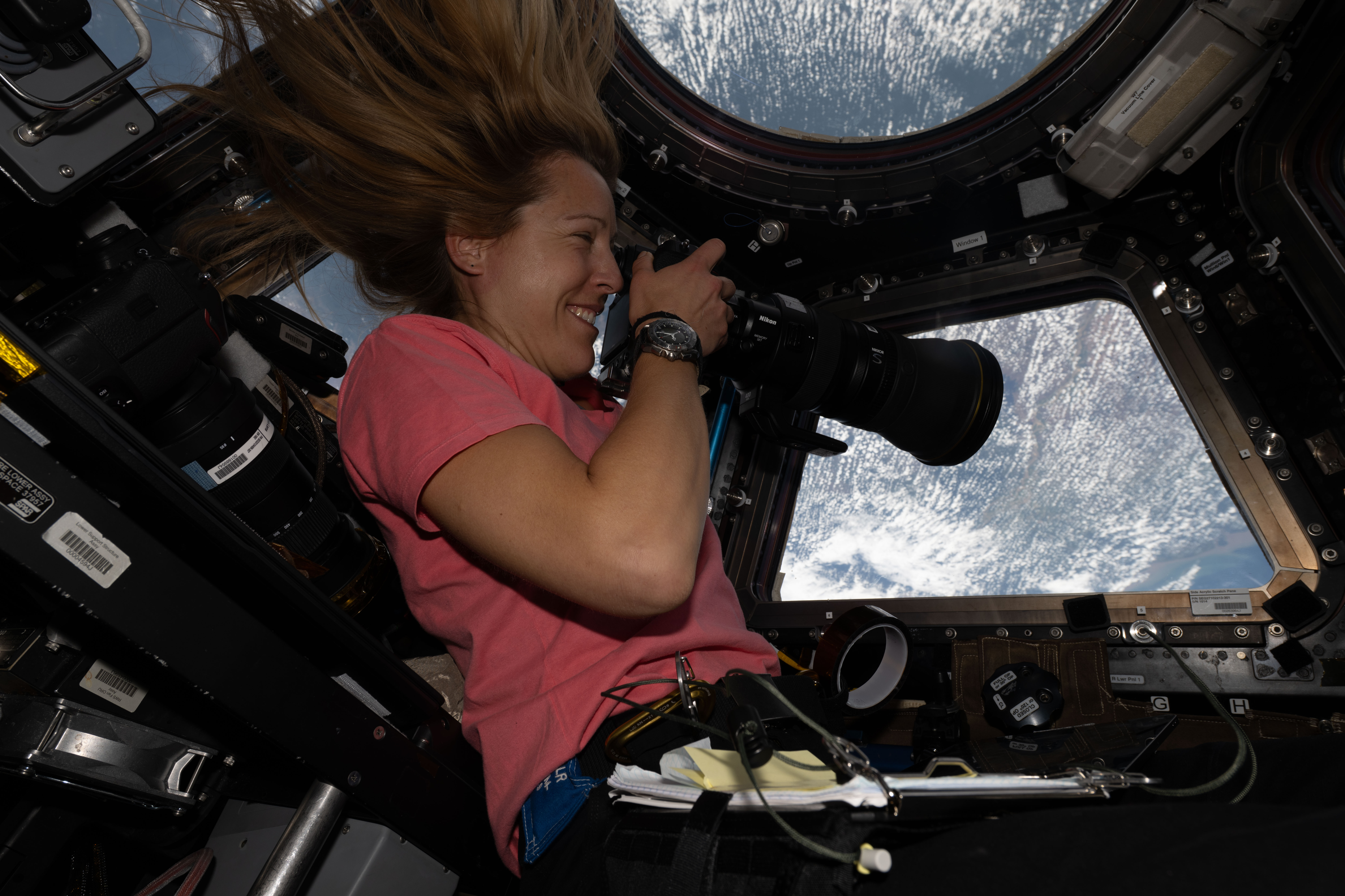 ESA astronaut Sophie Adenot points a camera out a cupola window