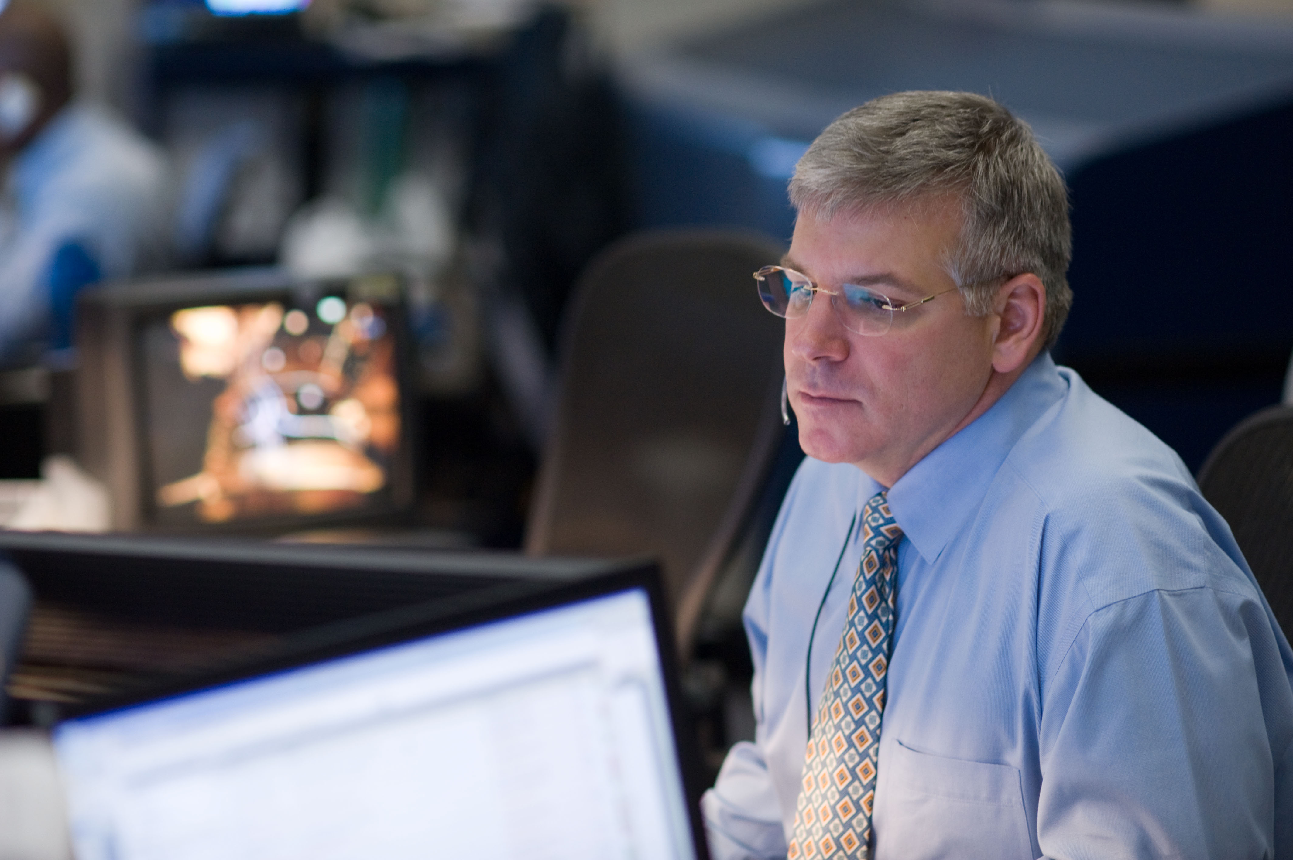 STS-119 Flight Director Mike Sarafin and flight controllers on console during the undocking and fly around phase.