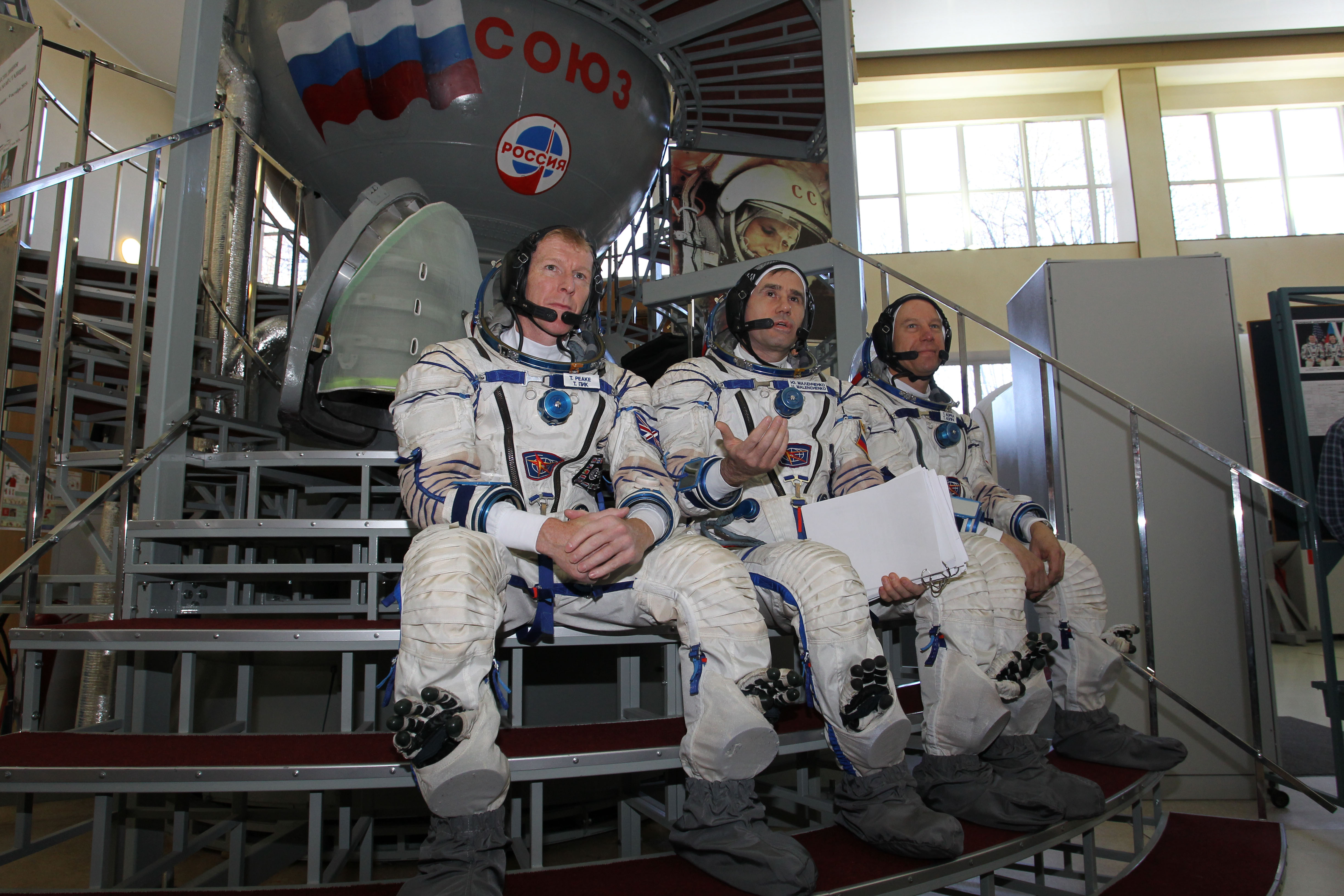 CG4G8787 --- (6 May 2015) --- At the Gagarin Cosmonaut Training Center in Star City, Russia, Expedition 44/45 backup crewmembers Timothy Peake of the European Space Agency (left), Yuri Malenchenko of the Russian Federal Space Agency (Roscosmos, center) and Timothy Kopra of NASA (right) answer questions from reporters in front of a Soyuz spacecraft simulator May 6 as part of their final qualification exams for flight. They are the backups to the prime crew --- Kjell Lindgren of NASA, Oleg Kononenko of Roscosmos and Kimya Yui of the Japan Aerospace Exploration Agency --- who are in the final stages of training for launch May 27, Kazakh time, in the Soyuz TMA-17M spacecraft to begin a five and a half month mission to the International Space Station. Photo credit: NASA/Seth Marcantel