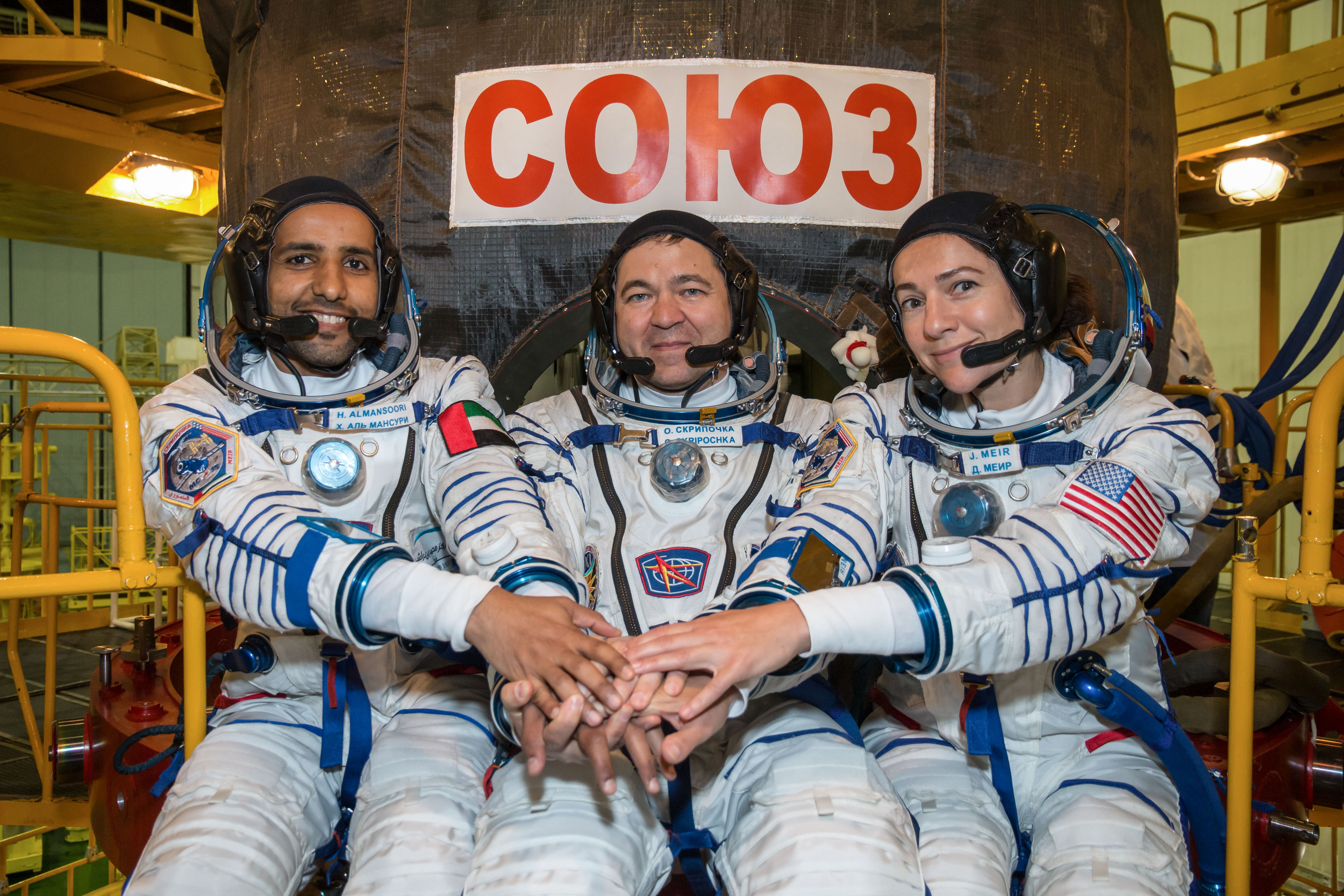 jsc2019e052892 - In the Integration Building at the Baikonur Cosmodrome in Kazakhstan, spaceflight participant Hazzaa Ali Almansoori of the United Arab Emirates (left) and Expedition 61 crewmates Oleg Skripochka of Roscosmos (center) and Jessica Meir of N