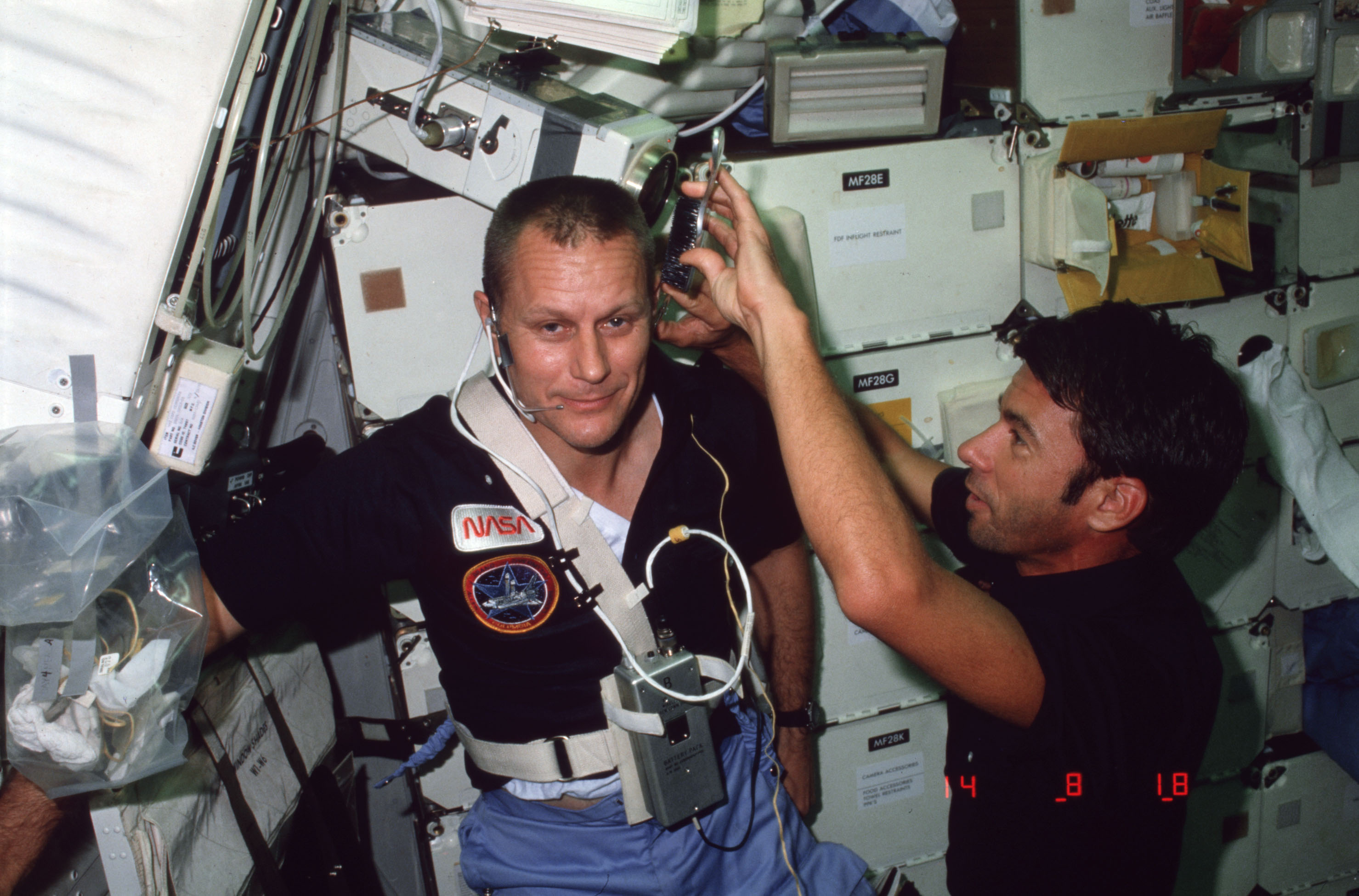 Mission Specialist (MS) Lenoir cuts Pilot Overmyer's hair on middeck
