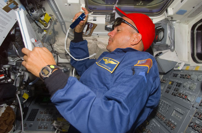 Sturckow in the orbiter flight deck gives instructions to the EVA astronauts