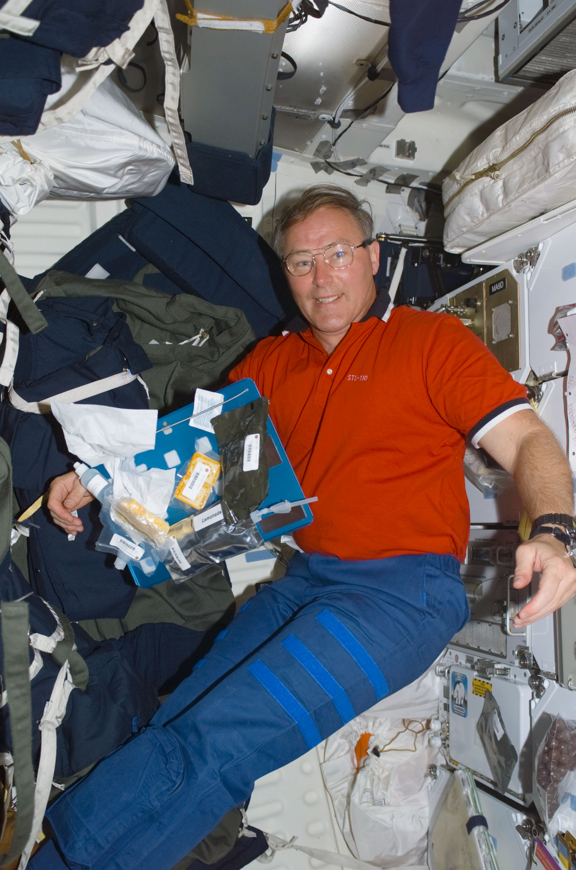 MS Ross eats a meal on the middeck of Atlantis during STS-110