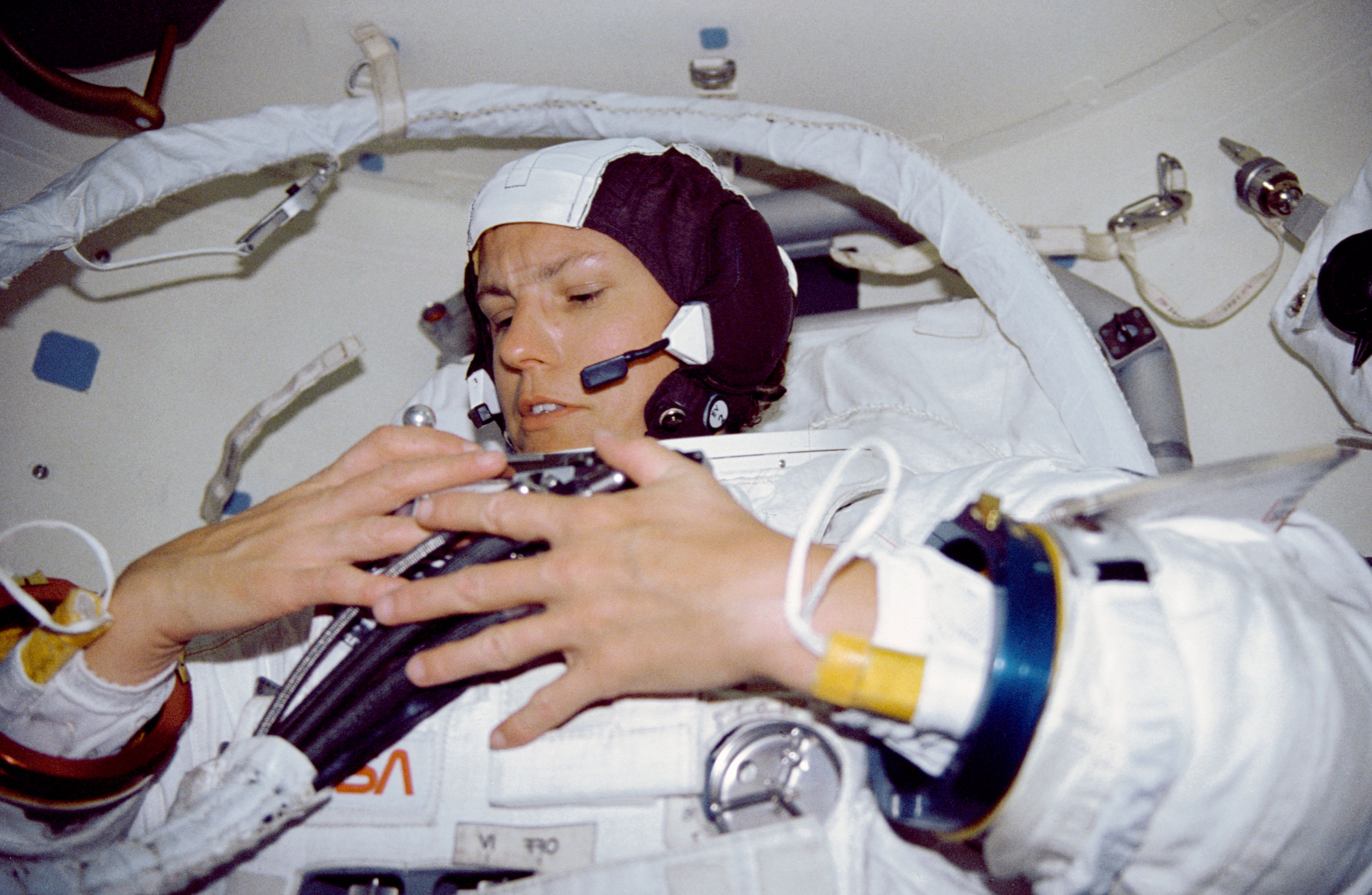 STS-31 Mission Specialist (MS) Sullivan dons EMU in OV-103's airlock
