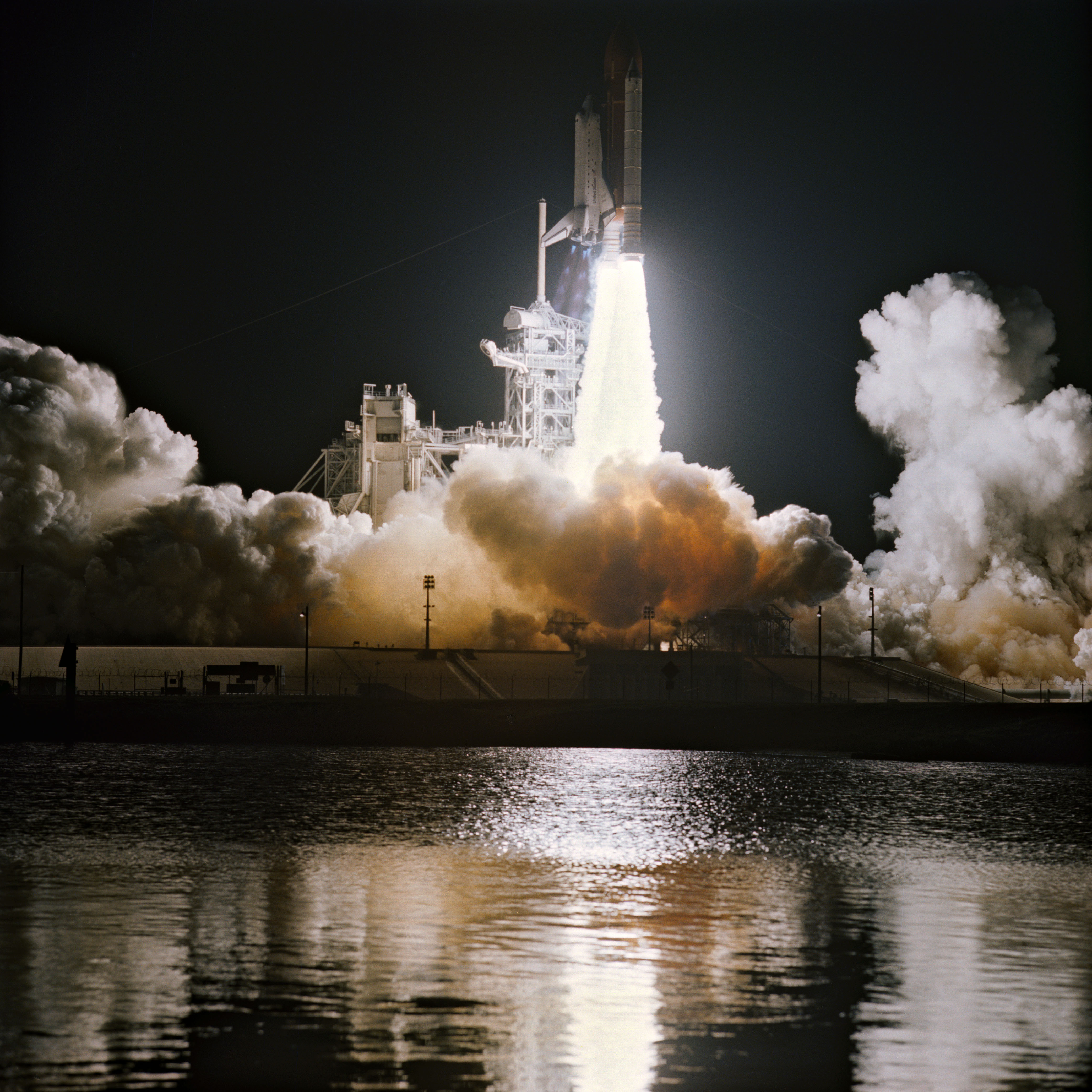 STS-36 Atlantis, OV-104, lifts off from KSC LC Pad 39A into darkness