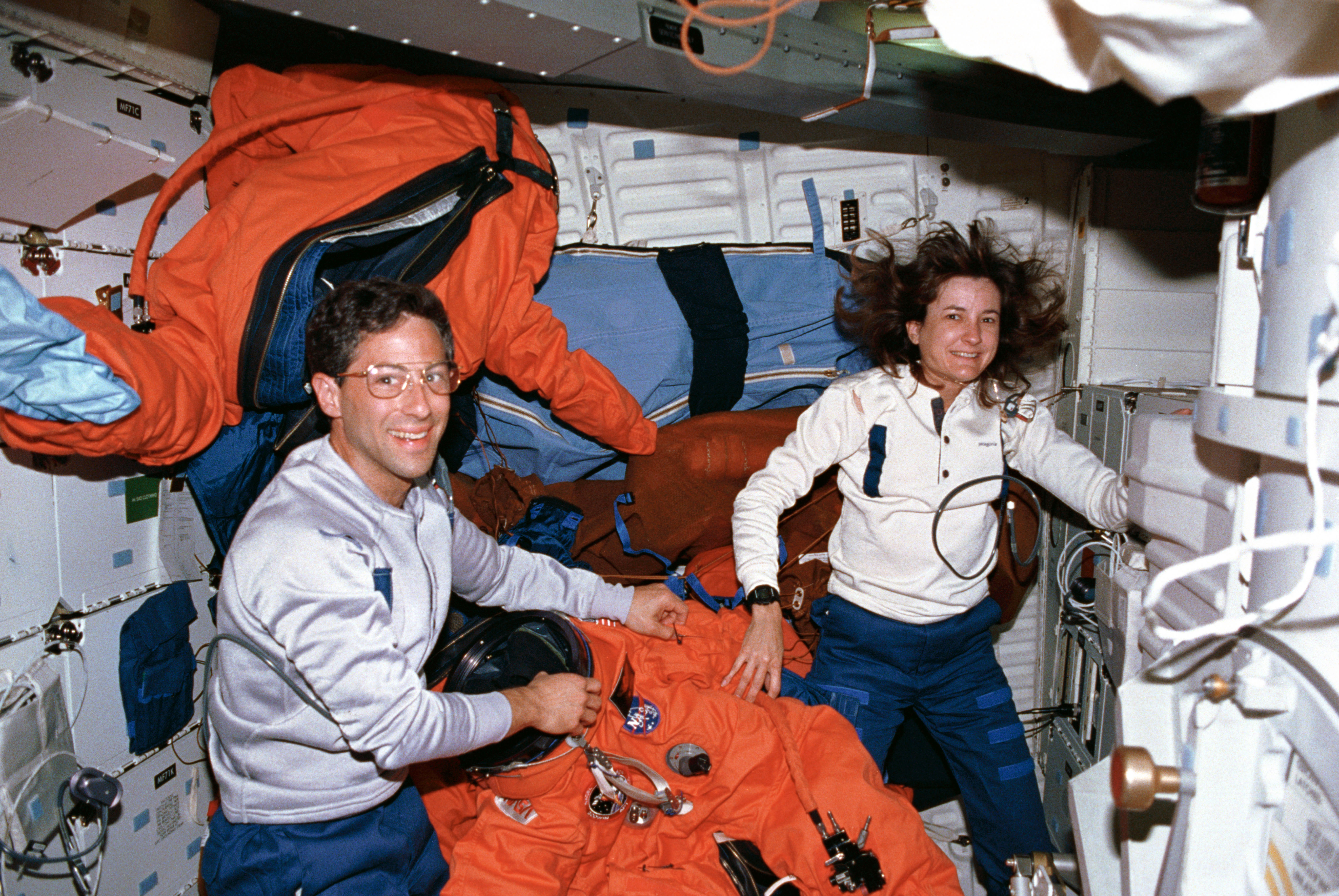 STS-37 crewmembers check launch and entry suits (LESs) on OV-104's middeck