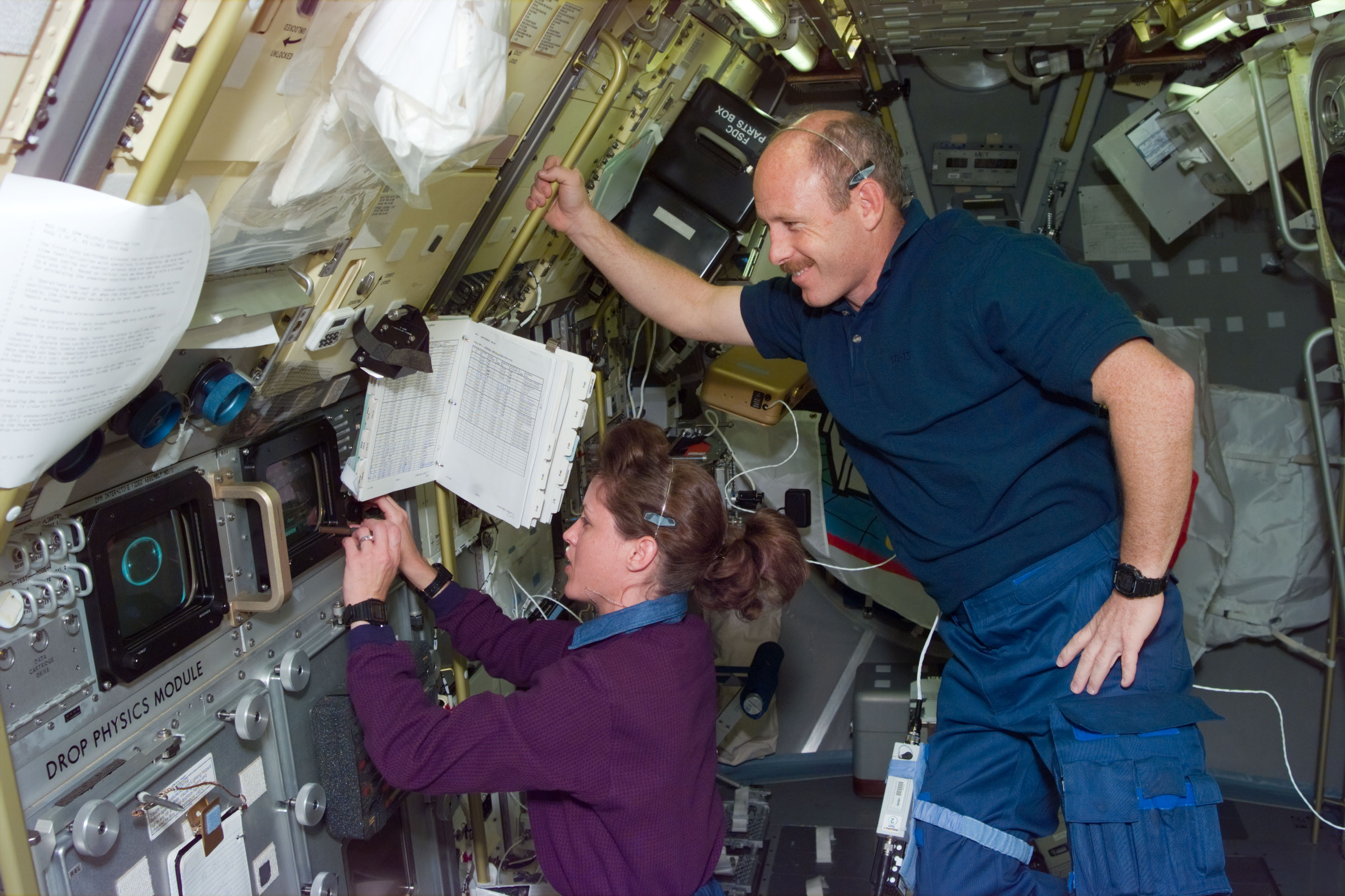 DPM, Payload Commander Kathy Thornton works with experiment as Bowersox watches