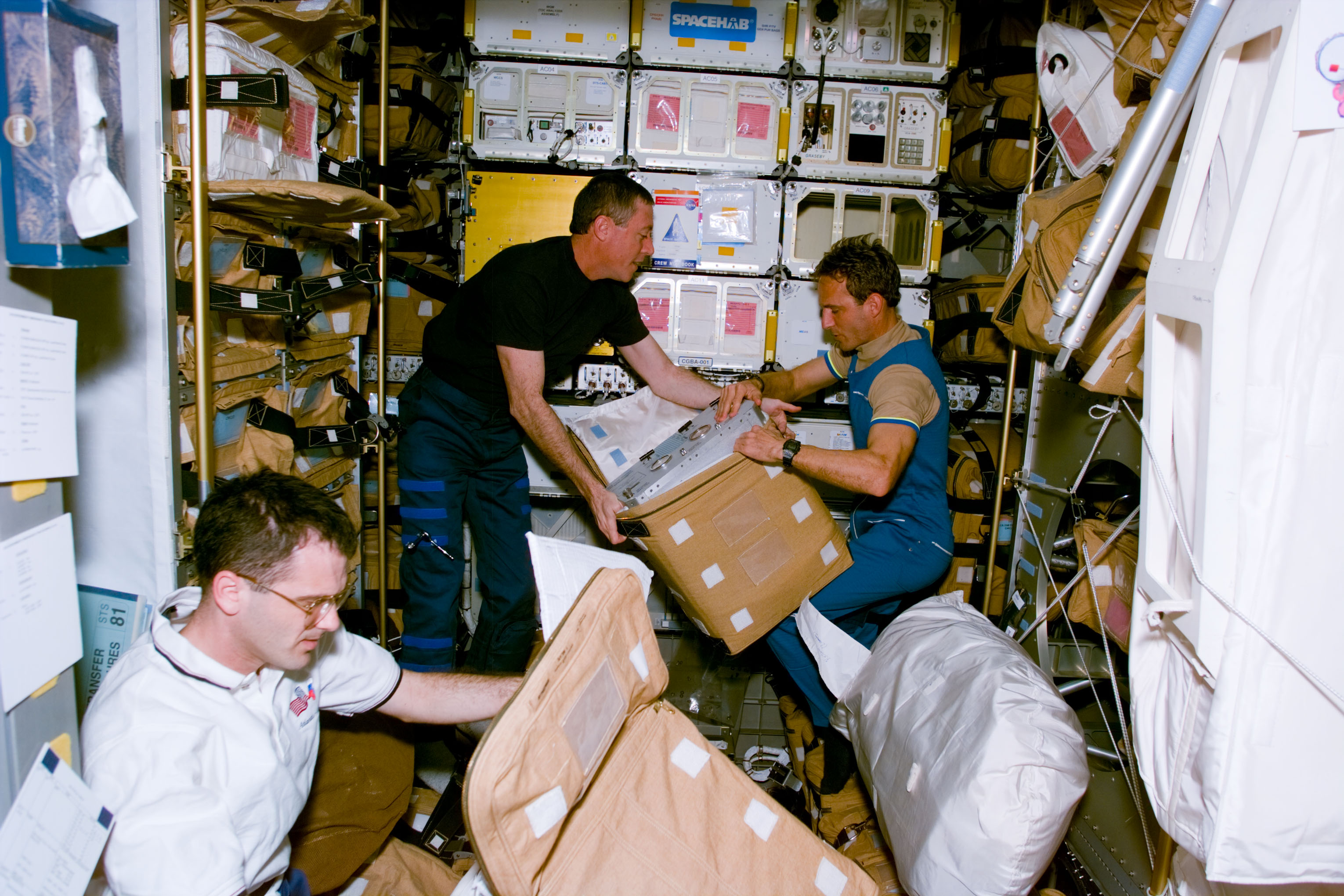 STS-81 crew packs hardware for stowage in the Spacehab
