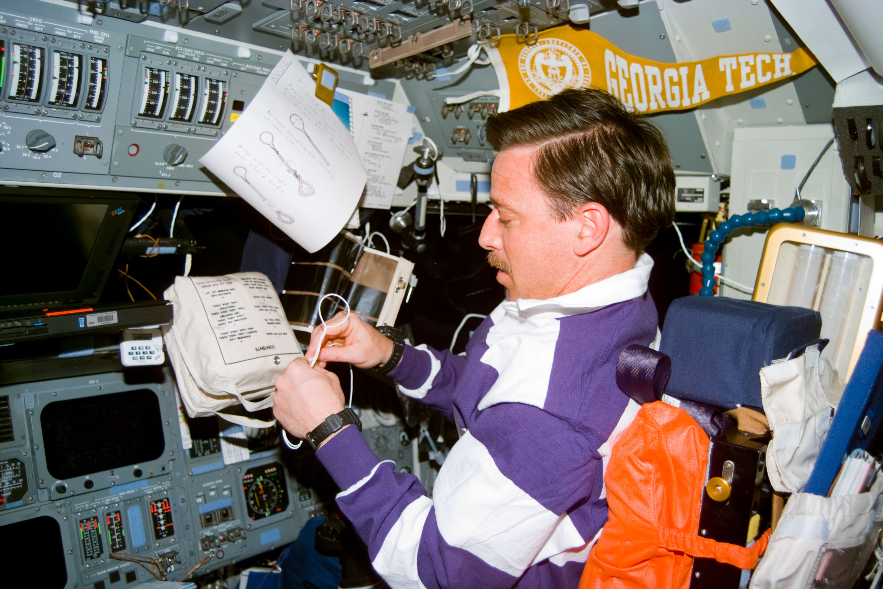 Pilot Scott Horowitz fashions cord loop fasteners for a contingency spacewalk