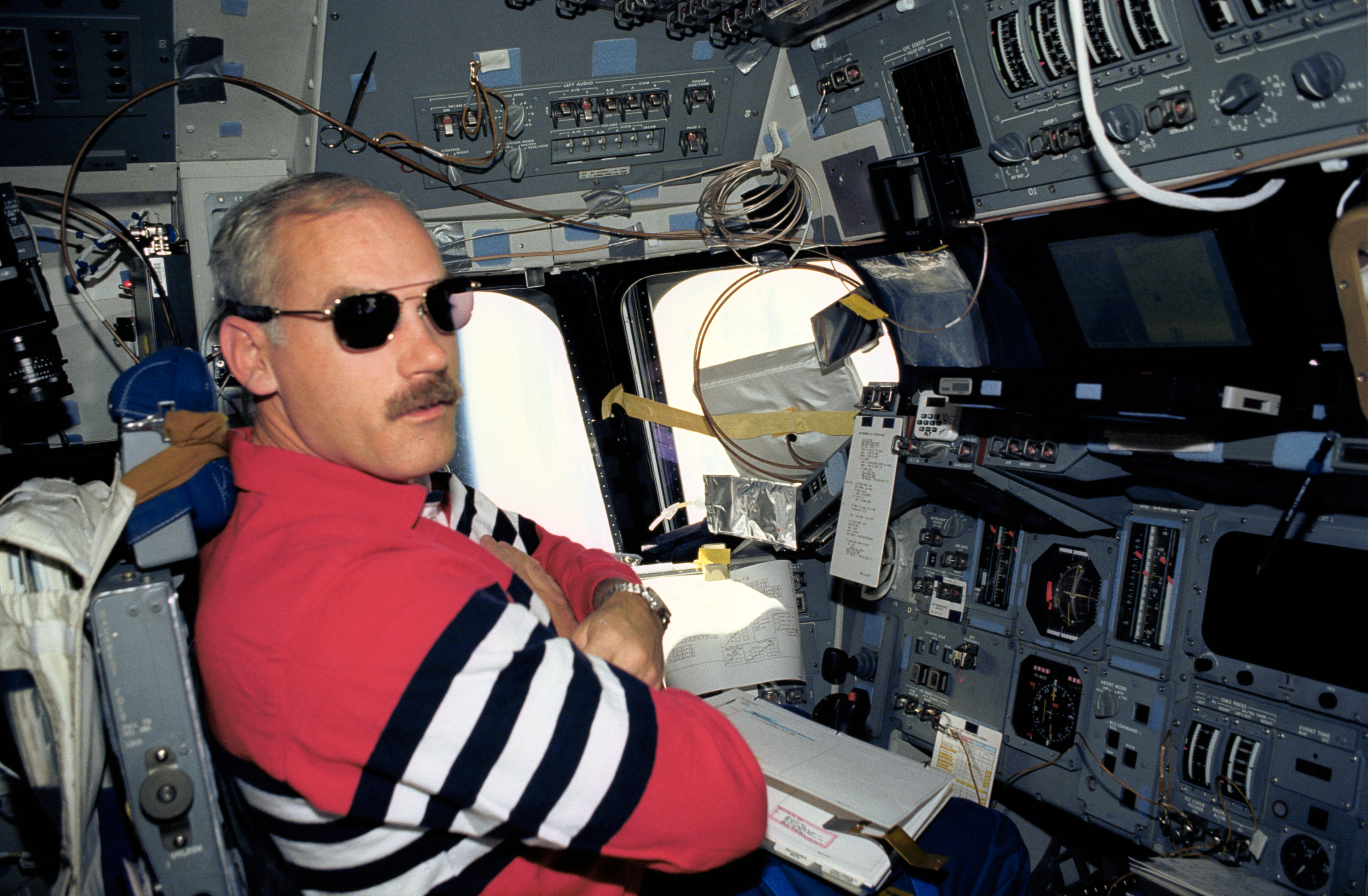 Astronaut William Readdy on flight deck wearing sun glasses