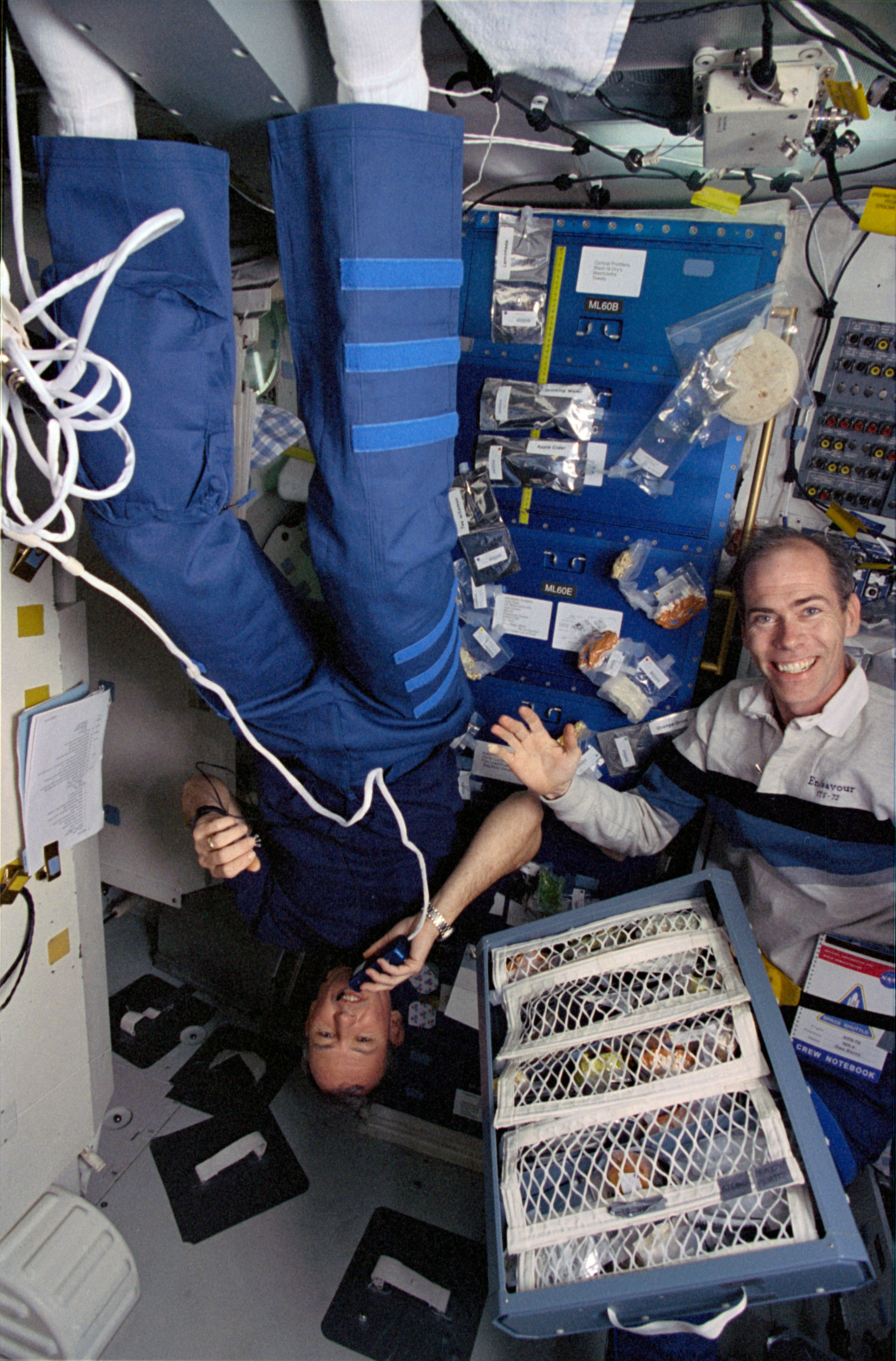 Astronauts Brian Duffy and Dan Barry team up to prepare a meal