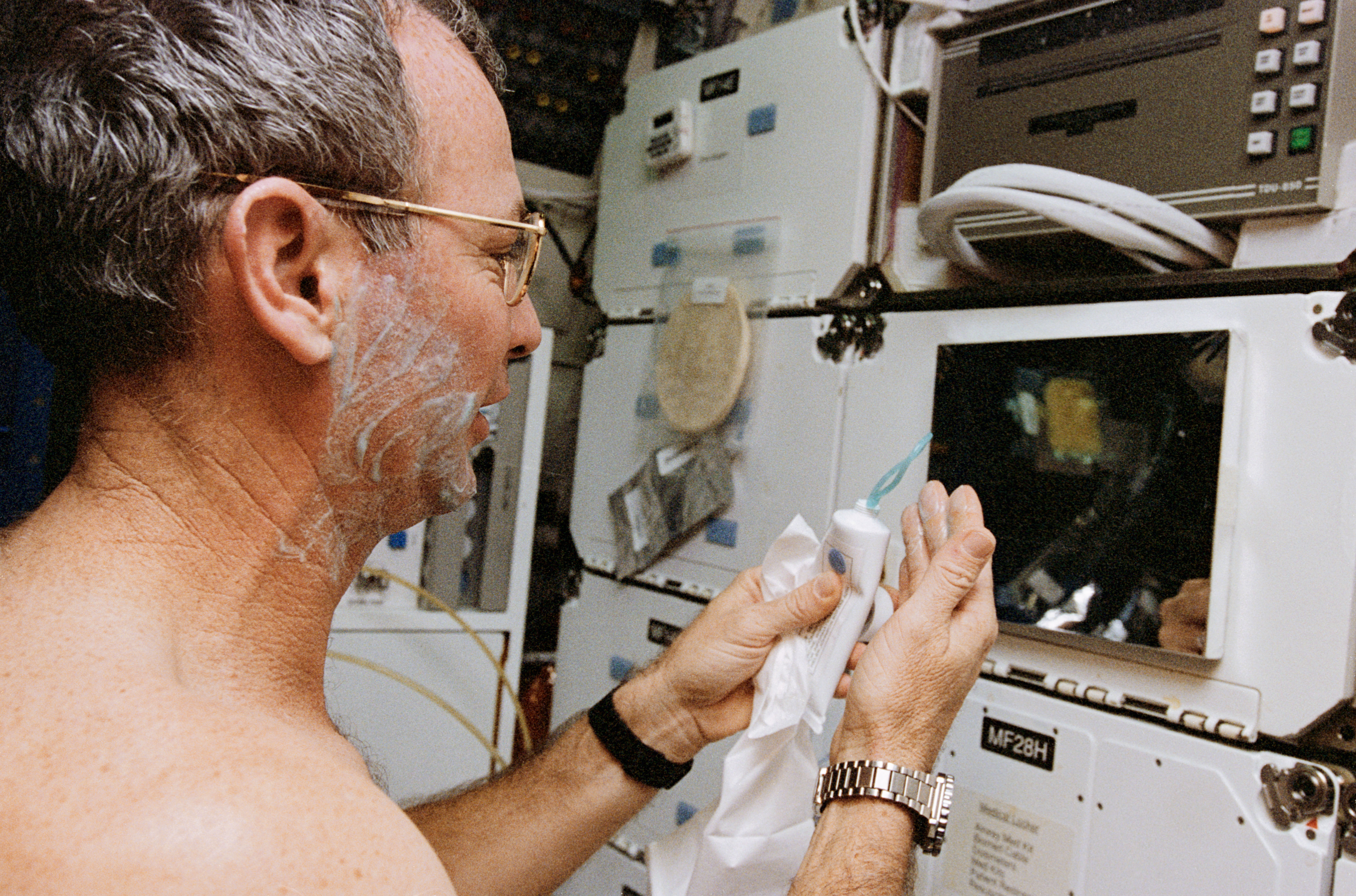 Astronaut Brian Duffy shaves in the middeck