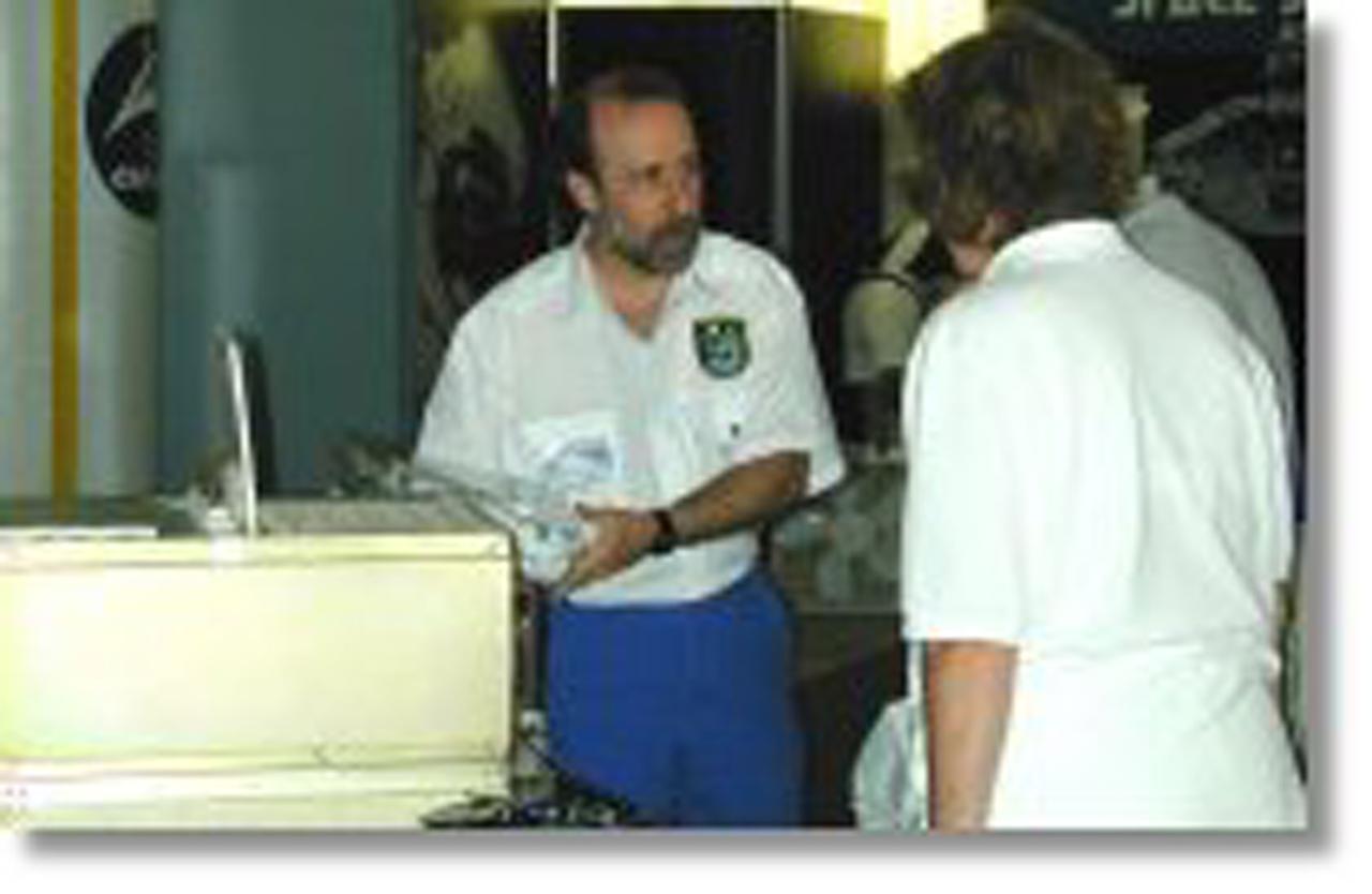 SPD representative Steve Lambing shows the PentaPure water purification unit to some EAA visitors. The Microgravity Research and the Space Product Development Programs joined with the Johnson Space Center (JSC) for a first time ever ISS/Microgravity Research space-focused exhibit at Oshkosh AirVenture'99 from July 28-August 3, 1999. The Space Product Development (SPD) display included the STS-95 ASTROCULTURE training hardware used by John Glenn and his crewmates, a PentaPure water purfication system, and a Ford engine block.