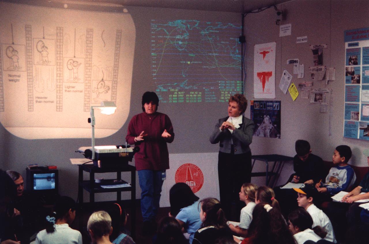 Paula Crawford (assisted by an American Sign Language interpreter) lectures students about materials science research in space during the U.S. Microgravity Payload-4 mission (STS-87, Nov. 19 - Dec. 5, 1997) in the visitor's center set up by the Isothermal Dendritic Growth Experiment (IDGE) team at Rensselaer Polytechnic Institute (RPI) in Troy, NY. IDGE, flown on three Space Shuttle mission, is yielding new insights into virtually all industrially relevant metal and alloy forming operation. Photo credit: Rensselaer Polytechnic Institute (RPI)