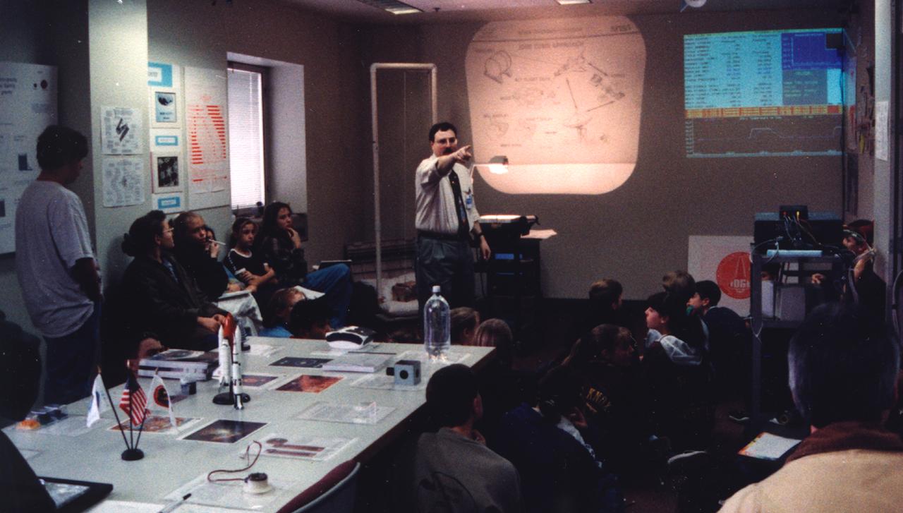Matthew Koss lectures middle-school students about materials science research in space during the U.S. Microgravity Payload-4 (USMP-4) mission (STS-87, Nov. 19 - Dec. 5, 1997) in the visitor's center set up by the Isothermal Dendritic Growth Experiment (IDGE) team at Rensselaer Polytechnic Institute (RPI)in Troy, NY. IDGE, flown on three Space Shuttle missions, is yielding new insights into virtually all industrially relevant metal and alloy forming operations. Photo credit: RPI