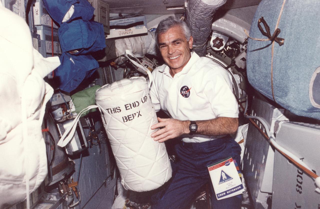 Astronaut Michael Clifford places a liquid nitrogen Dewar containing frozen protein solutions aboard Russia's space station Mir during a visit by the Space Shuttle (STS-76). The protein samples were flash-frozen on Earth and will be allowed to thaw and crystallize in the microgravity environment on Mir Space Station. A later crew will return the Dewar to Earth for sample analysis. Dr. Alexander McPherson of the University of California at Riverside is the principal investigator. Photo credit: NASA/Johnson Space Center.