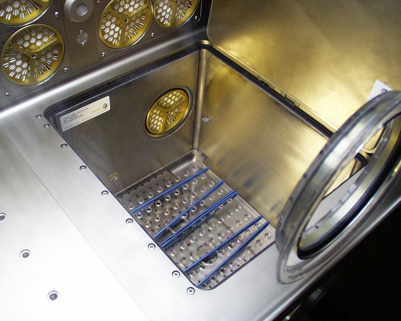 This photo shows the access through the internal airlock (bottom right) on the Microgravity Science Glovebox (MSG) being developed by the European Space Agency (ESA) and NASA for use aboard the International Space Station (ISS). The airlock will allow the insertion or removal of equipment and samples without opening the working volume of the glovebox. Scientists will use the MSG to carry out multidisciplinary studies in combustion science, fluid physics and materials science. The MSG is managed by NASA's Marshall Space Flight Center (MSFC). Photo Credit: NASA/MSFC