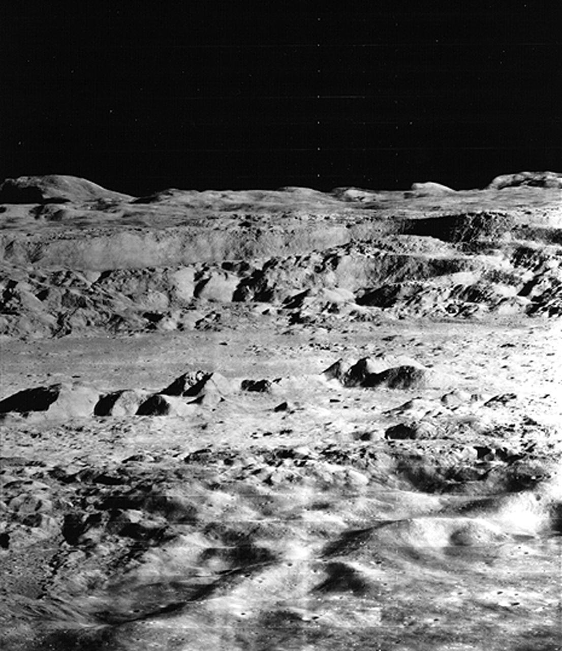 Lunar Orbiter 2 oblique northward view towards Copernicus crater on the Moon shows crater wall slumping caused by soil liquefaction following the impact that formed the crater. The crater is about 100 km in diameter. The central peaks are visible towards the top of the image, rising about 400 m above the crater floor, and stretching for about 15 km. The northern wall of the crater is in the background. Sand and soil grains have faces that can cause friction as they roll and slide against each other, or even cause sticking and form small voids between grains. This complex behavior can cause soil to behave like a liquid under certain conditions such as earthquakes or when powders are handled in industrial processes. MGM experiments aboard the Space Shuttle use the microgravity of space to simulate this behavior under conditions that carnot be achieved in laboratory tests on Earth. MGM is shedding light on the behavior of fine-grain materials under low effective stresses. Applications include earthquake engineering, granular flow technologies (such as powder feed systems for pharmaceuticals and fertilizers), and terrestrial and planetary geology. Nine MGM specimens have flown on two Space Shuttle flights. Another three are scheduled to fly on STS-107. The principal investigator is Stein Sture of the University of Colorado at Boulder. (Credit: University of Colorado at Boulder).