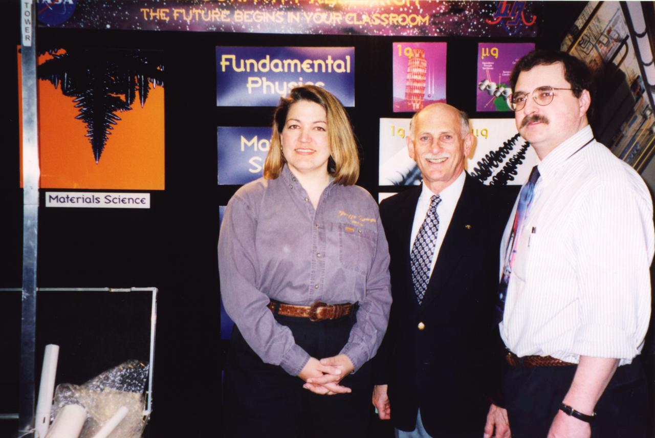 Representatives of NASA materials science experiments supported the NASA exhibit at the Rernselaer Polytechnic Institute's Space Week activities, April 5 through 11, 1999. From left to right are: Angie Jackman, project manager at NASA's Marshall Space Flight Center for dendritic growth experiments; Dr. Martin Glicksman of Rennselaer Polytechnic Instutute, Troy, NY, principal investigator on the Isothermal Dendritic Growth Experiment (IDGE) that flew three times on the Space Shuttle; and Dr. Matthew Koss of College of the Holy Cross in Worcester, MA, a co-investigator on the IDGE and now principal investigator on the Transient Dendritic Solidification Experiment being developed for the International Space Station (ISS). The image at far left is a dendrite grown in Glicksman's IDGE tests aboard the Shuttle. Glicksman is also principal investigator for the Evolution of Local Microstructures: Spatial Instabilities of Coarsening Clusters. 