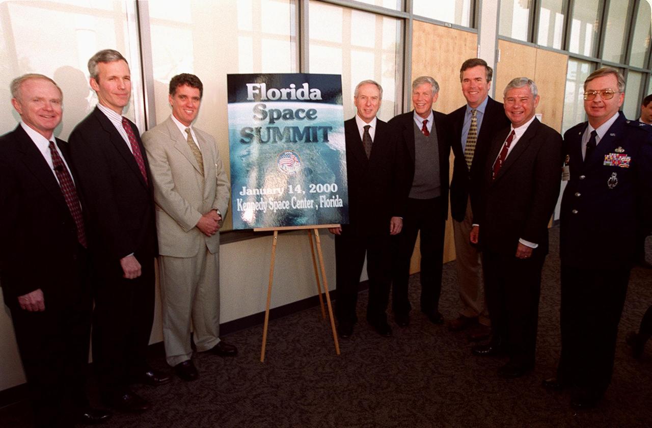 Before the start of the First Florida Space Summit, participants gather around the poster. From left are Center Director Roy Bridges, Representative Jim Davis, Representative Dave Weldon, NASA Administrator Dan Goldin, Senator Connie Mack, Governor Jeb Bush, Senator Bob Graham and 45th Space Wing Commander Brig. Gen. Donald Pettit. The summit, which was held at the Kennedy Space Center Visitor Complex, featured key state officials and aerospace companies to discuss the future of space as it relates to the State of Florida. Moderated by Bridges, the event also included State Senator Patsy Kurth, State Senator Charlie Bronson, and State Representative Randy Ball