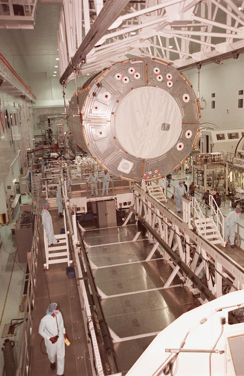 KENNEDY SPACE CENTER, FLA. -- In the Space Station Processing Facility, the U.S. Lab Destiny is lowered toward the Launch Package Integration Stand (LPIS) for a weight and center of gravity determination. Destiny is the payload aboard Space Shuttle Atlantis on mission STS-98 to the Space Station. The lab is fitted with five system racks and will already have experiments installed inside for the flight. The launch is scheduled for January 2001