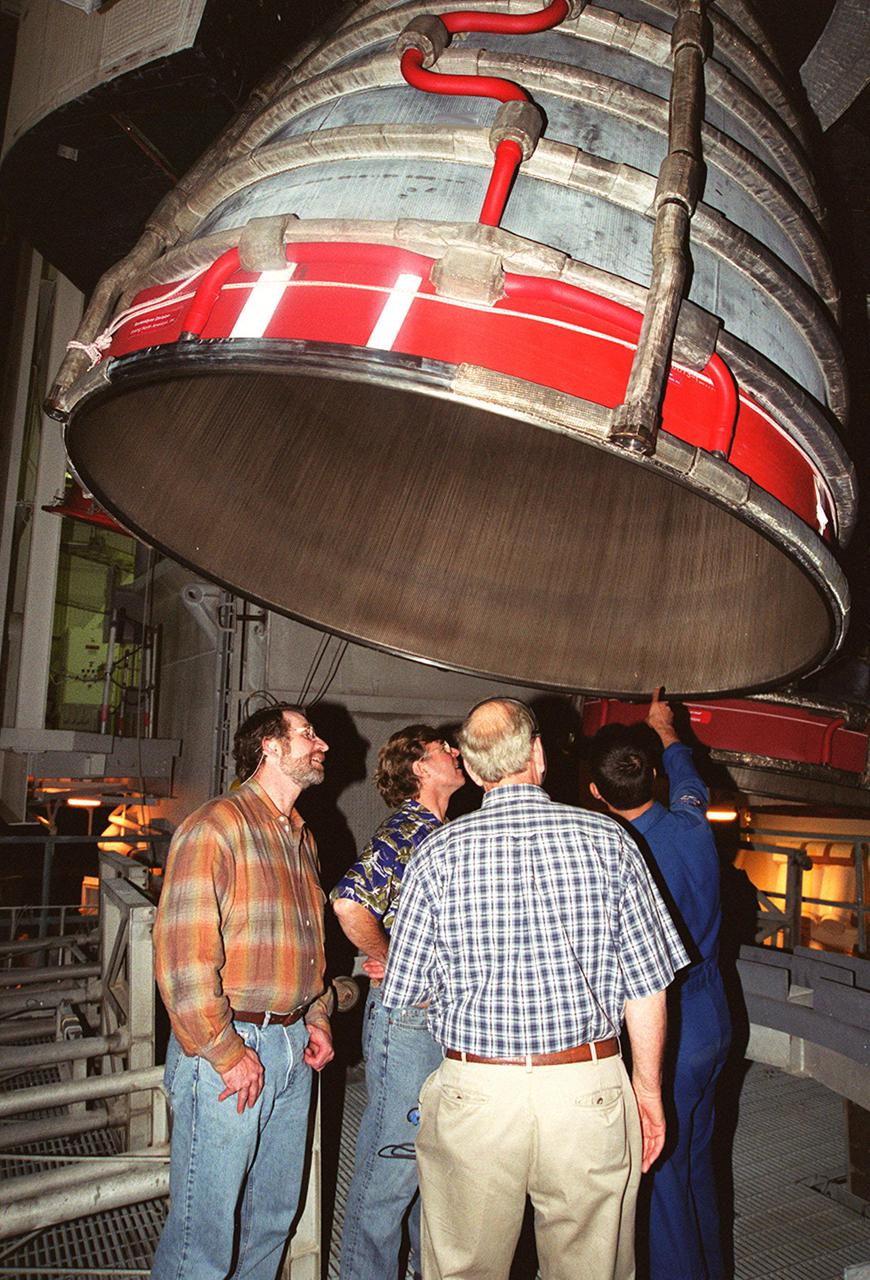 Members of the crew of the television series This Old House get a close look at one of the main engines on Space Shuttle Atlantis in the Vehicle Assembly Building. At left is Norm Abram, master carpenter on the series. Next to him is Steve Thomas, host of the show. At the far right is astronaut John Herrington, who is accompanying the film crew on their tour of KSC. The cast and crew of This Old House are filming at KSC for an episode of the show