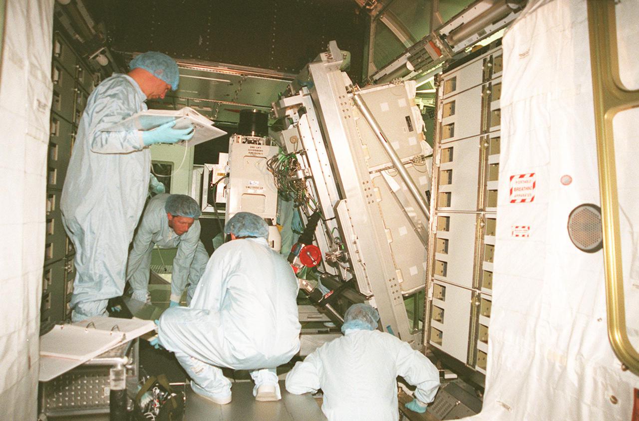 KENNEDY SPACE CENTER, FLA. -- Workers inside the Multi-Purpose Logistics Module Leonardo check connections while installing a laboratory rack. Leonardo is the first of three such pressurized modules that will serve as the International Space Station's “moving vans,” carrying laboratory racks filled with equipment, experiments and supplies to and from the Space Station aboard the Space Shuttle. Approximately 21 feet long and 15 feet in diameter, Leonardo will be launched on Shuttle mission STS-102 March 1, 2001. On that flight, Leonardo will be filled with equipment and supplies to outfit the U.S. laboratory module, being carried to the ISS on the Jan. 19, 2001, launch of STS-98