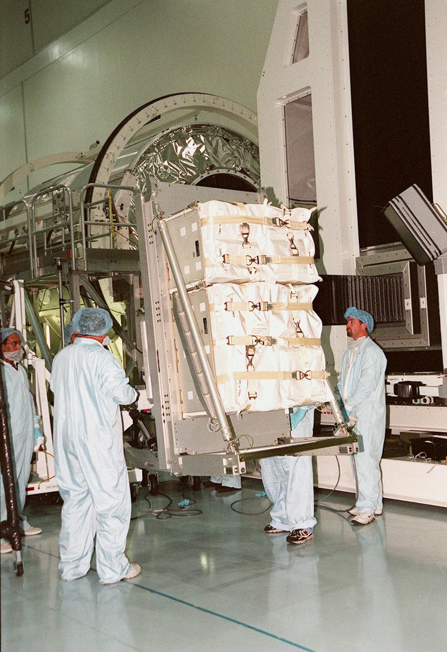 KENNEDY SPACE CENTER, FLA. -- In the Space Station Processing Facility, another laboratory rack is placed on the arm of the Rack Insertion Unit to lift it to the workstand height of the Multi-Purpose Logistics Module Leonardo (not seen). The MPLM will transport laboratory racks filled with equipment, experiments and supplies to and from the International Space Station aboard the Space Shuttle. Leonardo will be launched for the first time March 1, 2001, on Shuttle mission STS-102. On that flight, Leonardo will be filled with equipment and supplies to outfit the U.S. laboratory module, being carried to the ISS on the Jan. 19, 2001, launch of STS-98