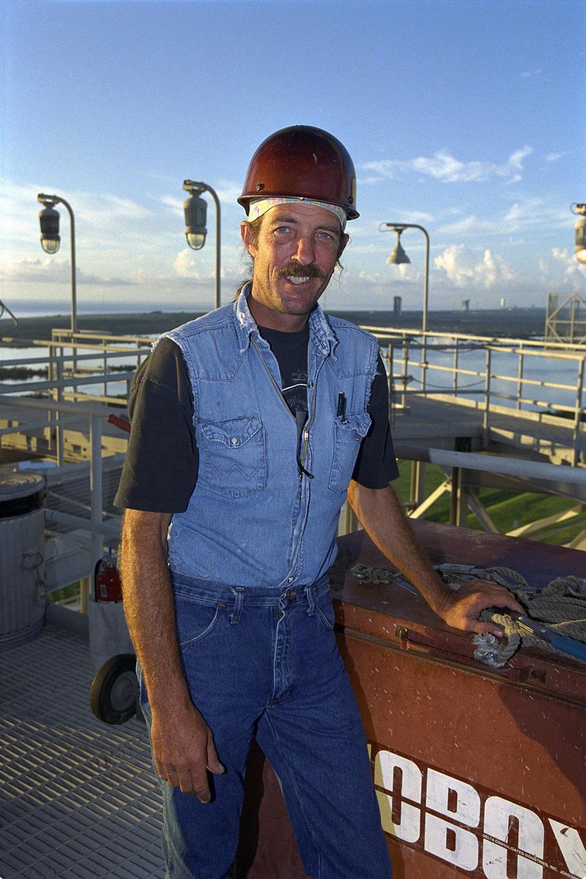 KENNEDY SPACE CENTER, FLA. -- Day in the Life page 2. Preparing the pad. Workers maintain Pad A at Kennedy Space Center’s Launch Complex 39. Robert Lust of IVEY Construction pauses on his way to install a safety handrail. This photograph was taken for a special color edition of Spaceport News designed to portray in photographs a single day at KSC, July 26, 2000. The special edition, published Aug. 25, 2000, was created to give readers a look at KSC’s diverse workforce and the critical roles workers play in the nation’s space program. Spaceport News is an official publication of the Kennedy Space Center and is published on alternate Fridays by the Public Affairs Office in the interest of KSC civil service and contractor employees