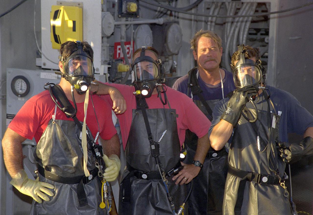 KENNEDY SPACE CENTER, FLA. -- Day in the Life, page 2. Preparing the pad. Workers maintain Pad A at Kennedy Space Center’s Launch Complex 39. A team of United Space Alliance workers don gas masks before calibrating the pad’s hypergolic fuel system. This photograph was taken for a special color edition of Spaceport News designed to portray in photographs a single day at KSC, July 26, 2000. The special edition, published Aug. 25, 2000, was created to give readers a look at KSC’s diverse workforce and the critical roles workers play in the nation’s space program. Spaceport News is an official publication of the Kennedy Space Center and is published on alternate Fridays by the Public Affairs Office in the interest of KSC civil service and contractor employees