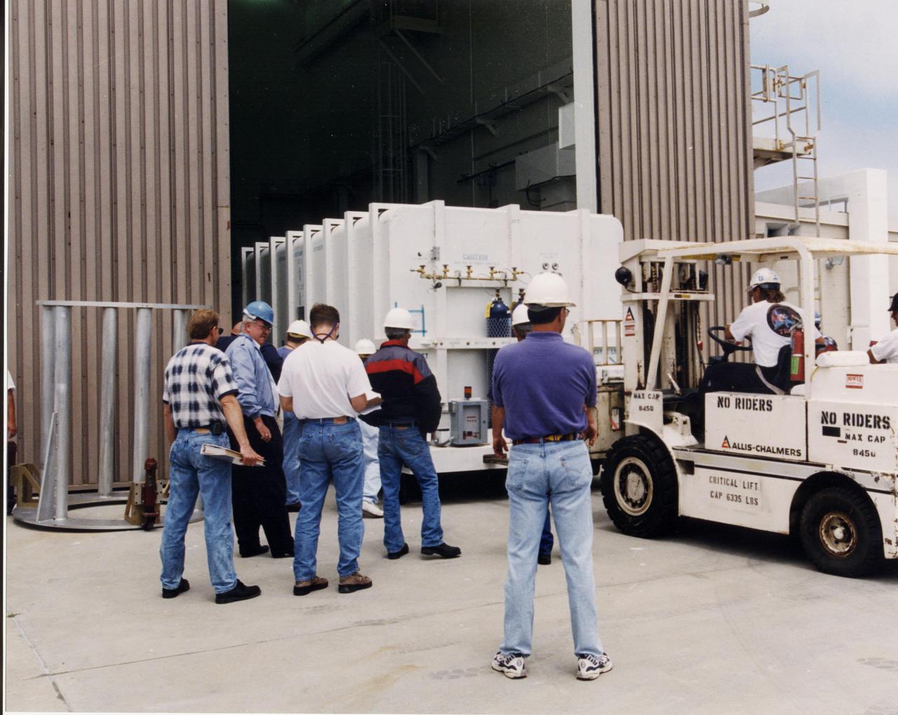 A crated National Oceanic and Atmospheric Administration (NOAA-L) satellite is moved inside the B16-10 spacecraft processing hangar at Vandenberg Air Force Base, Calif. NOAA-L is part of the Polar-Orbiting Operational Environmental Satellite (POES) program that provides atmospheric measurements of temperature, humidity, ozone and cloud images, tracking weather patterns that affect the global weather and climate. The launch of the NOAA-L satellite is scheduled no earlier than Sept. 12 aboard a Lockheed Martin Titan II rocket