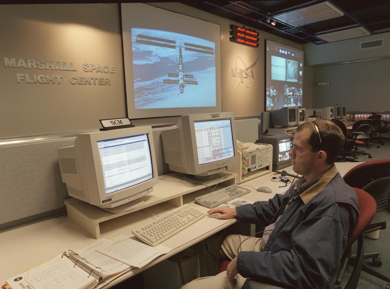 The Payload Operations Center (POC) is the science command post for the International Space Station (ISS). Located at NASA's Marshall Space Flight Center in Huntsville, Alabama, it is the focal point for American and international science activities aboard the ISS. The POC's unique capabilities allow science experts and researchers around the world to perform cutting-edge science in the unique microgravity environment of space. The POC is staffed around the clock by shifts of payload flight controllers. At any given time, 8 to 10 flight controllers are on consoles operating, plarning for, and controlling various systems and payloads. This photograph show the Safety Coordination Manager (SCM) at a work station. The SCM monitors science experiments to ensure they are conducted in a safe manner in accordance with strict safety regulations. 