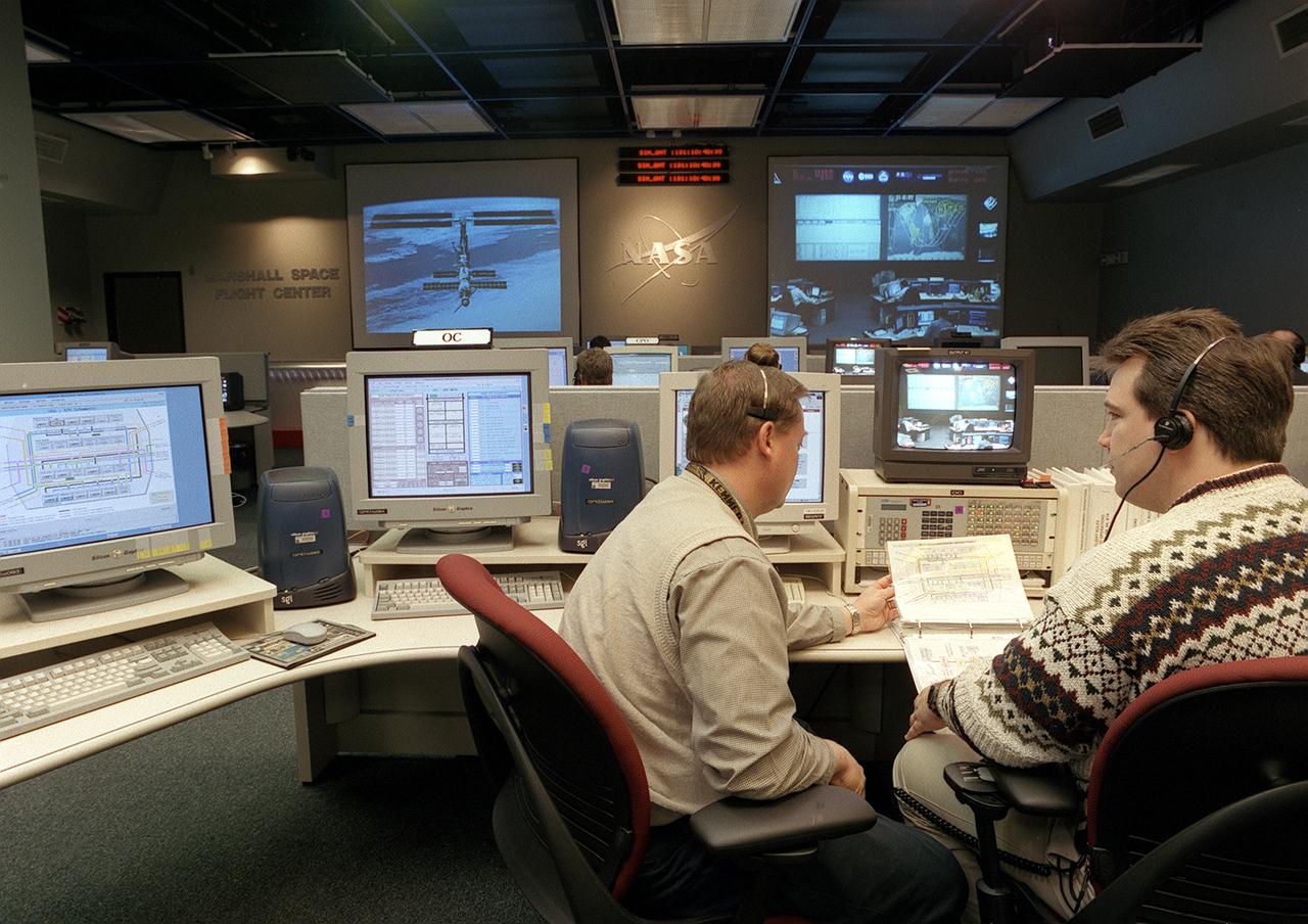 The Payload Operations Center (POC) is the science command post for the International Space Station (ISS). Located at NASA's Marshall Space Flight Center in Huntsville, Alabama, it is the focal point for American and international science activities aboard the ISS. The POC's unique capabilities allow science experts and researchers around the world to perform cutting-edge science in the unique microgravity environment of space. The POC is staffed around the clock by shifts of payload flight controllers. At any given time, 8 to 10 flight controllers are on consoles operating, plarning for, and controlling various systems and payloads. This photograph shows the Operations Controllers (OC) at their work stations. The OC coordinates the configuration of resources to enable science operations, such as power, cooling, commanding, and the availability of items like tools and laboratory equipment. 