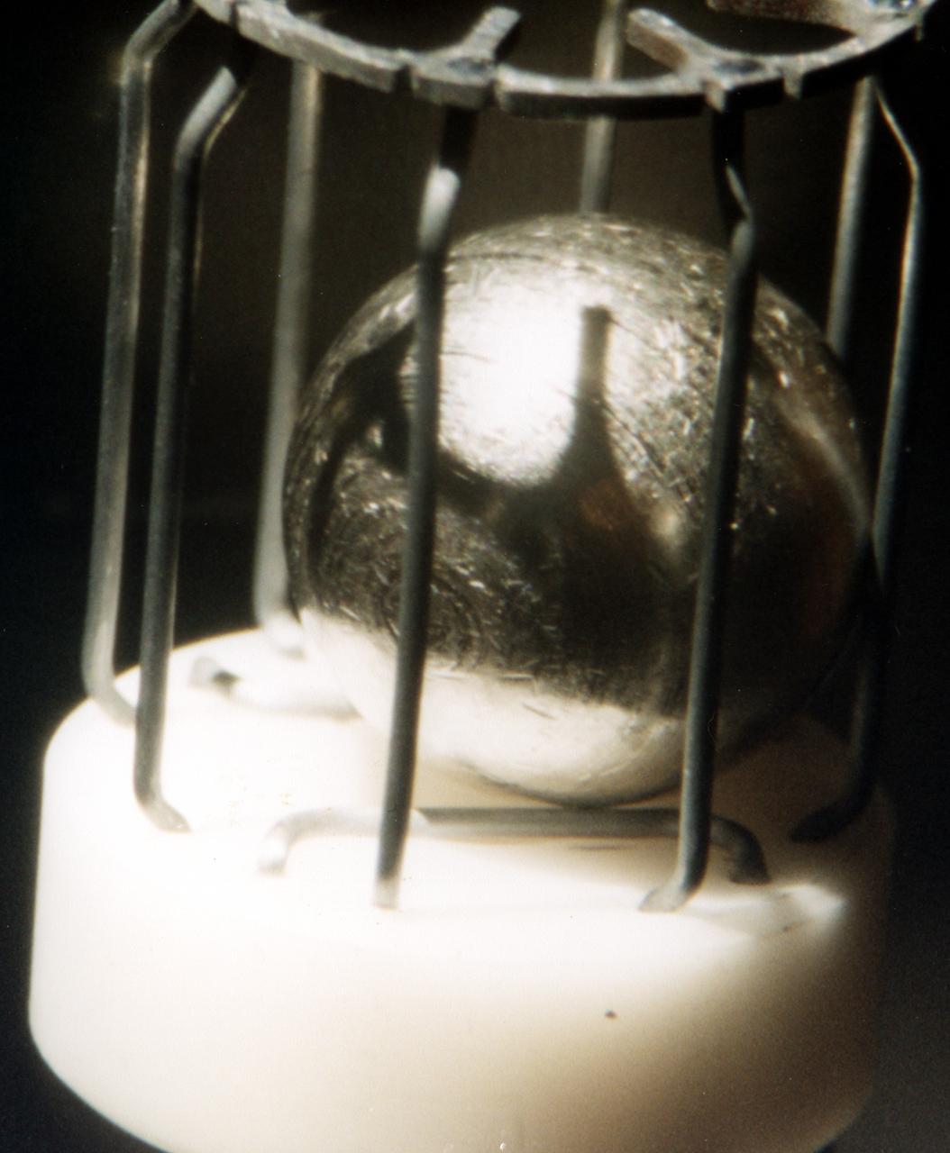 Typical metal sample that was processed by TEMPUS (Tiegelfreies Elektromagnetisches Prozessieren Unter Schwerelosigkeit), an electromagnetic levitation facility developed by German researchers and flown on the IML-2 and MSL-1 and 1R Spacelab missions. Electromagnetic levitation is used commonly in ground-based experiments to melt and then cool metallic melts below their freezing points without solidification occurring. Sample size is limited in ground-based experiments. Research with TEMPUS aboard Spacelab allowed scientists to study the viscosity, surface tension, and other properties of several metals and alloys while undercooled (i.e., cooled below their normal solidification points). The sample is about 1 cm (2/5 inch) in diameter.