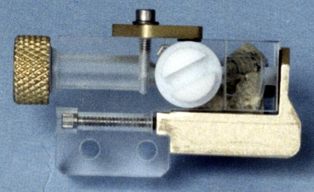 This photo shows an individual cell from the Handheld Diffusion Test Cell (HH-DTC) apparatus flown on the Space Shuttle. Similar cells will be used in the Observable Protein Crystal Growth Apparatus (OPCGA) to be operated aboard the International Space Station (ISS). The principal investigator is Dr. Alex McPherson of the University of California, Irvine. Each individual cell comprises two sample chambers with a rotating center section that isolates the two from each other until the start of the experiment and after it is completed. The cells are made from optical-quality quartz glass to allow photography and interferometric observations. Each cell has a small light-emitting diode and lens to back-light the solution. In protein crystal growth experiments, a precipitating agent such as a salt solution is used to absorb and hold water but repel the protein molecules. This increases the concentration of protein until the molecules nucleate to form crystals. This cell is one of 96 that make up the experiment module portion of the OPCGA.