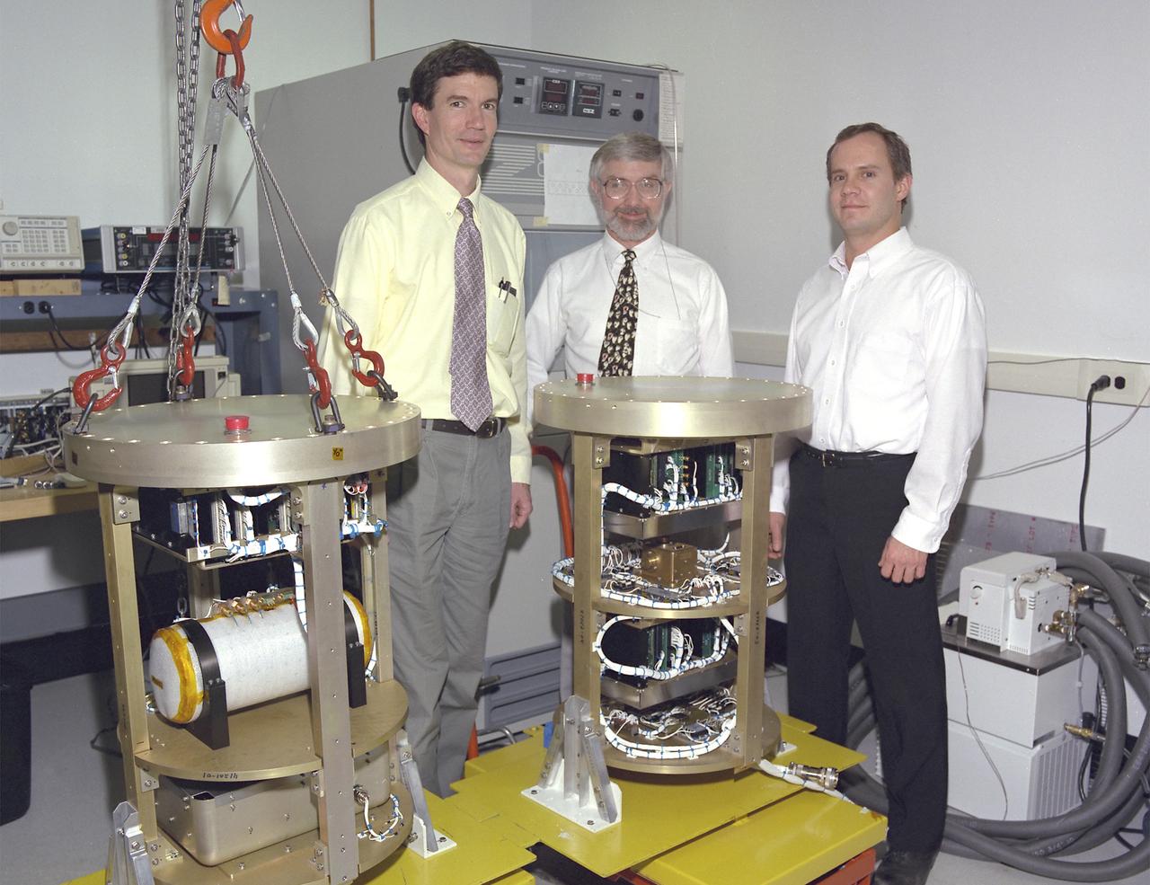 The Critical Viscosity of Xenon Experiment (CVX-2) on the STS-107 Research 1 mission in 2002 will measure the viscous behavior of xenon, a heavy inert gas used in flash lamps and ion rocket engines, at its critical point. The thermostat for CVX sits inside the white cylinder on a support structure (at left) that is placed inside a pressure canister. A similar canister (right) holds the electronics and control systems. The CVX-2 arrangement is identical. The principal investigator is Dr. Robert F. Berg (left) of the National Institutes of Standards and Technology, Gaithersburg, MD.