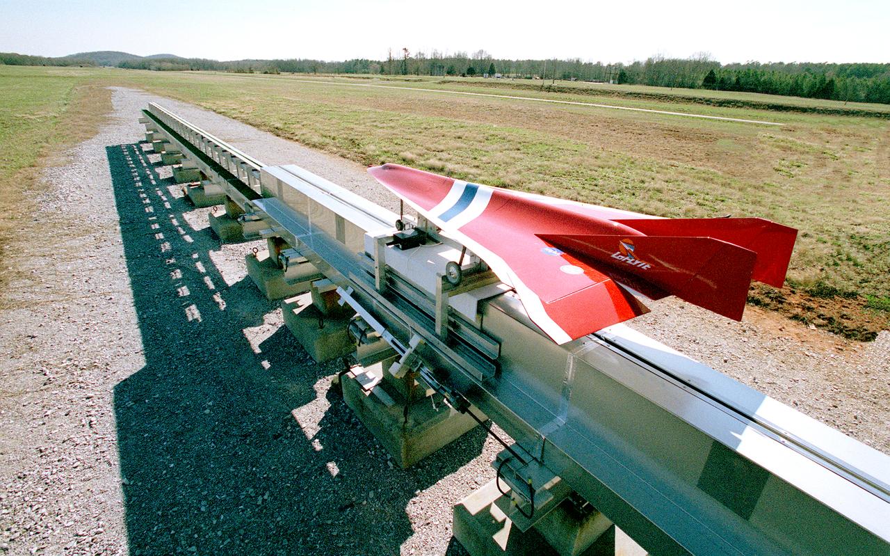 Engineers at the Marshall Space Flight Center (MSFC) have been testing Magnetic Launch Assist Systems, formerly known as Magnetic Levitation (MagLev) technologies. To launch spacecraft into orbit, a Magnetic Launch Assist system would use magnetic fields to levitate and accelerate a vehicle along a track at a very high speed. Similar to high-speed trains and roller coasters that use high-strength magnets to lift and propel a vehicle a couple of inches above a guideway, the  launch-assist system would electromagnetically drive a space vehicle along the track. A full-scale, operational track would be about 1.5-miles long and capable of accelerating a vehicle to 600 mph in 9.5 seconds. This photograph shows a subscale model of an airplane running on the experimental track at MSFC during the demonstration test. This track is an advanced linear induction motor. Induction motors are common in fans, power drills, and sewing machines. Instead of spinning in a circular motion to turn a shaft or gears, a linear induction motor produces thrust in a straight line. Mounted on concrete pedestals, the track is 100-feet long, about 2-feet wide, and about 1.5- feet high. The major advantages of launch assist for NASA launch vehicles is that it reduces the weight of the take-off, the landing gear, the wing size, and less propellant resulting in significant cost savings. The US Navy and the British MOD (Ministry of Defense) are planning to use magnetic launch assist for their next generation aircraft carriers as the aircraft launch system.  The US Army is considering using this technology for launching target drones for anti-aircraft training. 