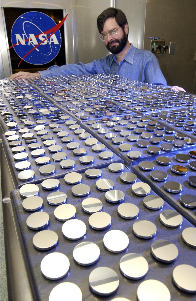 In this photograph, Vince Huegele of the Marshall Space Flight Center's (MSFC's) Space Optics Manufacturing Technology Center (SOMTC) inspects the coating on the mirrors for Starshine 3, a satellite that resembles a high-tech disco ball that was placed into Earth orbit. The sphere, which is covered by hundreds of quarter-sized mirrors that reflect sunlight to observers on the ground, helps students study the effects of solar activity on the Earth's atmosphere. Ed White Middle School in Huntsville, Alabama is among 500 schools worldwide whose students helped grind and polish mirrors for the Starshine 3 satellite as a part of the Starshine Project. The total of up to 1,500 mirrors will improve the sunlight flash rate and make the satellite more visible at twilight as it orbits the Earth. These mirrors have been coated with a scratch-resistant, anti-oxidizing layer of silicon dioxide by optical engineers and technicians at the Hill Air Force Base in Utah and MSFC. Starshine-3 was launched on an Athena I unmarned launch vehicle out of the Kodiak Launch Complex, Alaska, on September 29, 2001. Starshine 3 is nearly 37 inches (1 meter) in diameter, weighs 200 pounds (91 kilograms), and carries 1500 mirrors that were polished by approximately 40,000 students in 1,000 schools in 30 countries. Three small, optically-reflective spherical Starshine student satellites have been designed by the U.S. Naval Research Laboratory and built by an informal volunteer coalition of organizations and individuals in the U.S. and Canada. This coalition, called Project Starshine, is headquartered in Monument, Colorado.