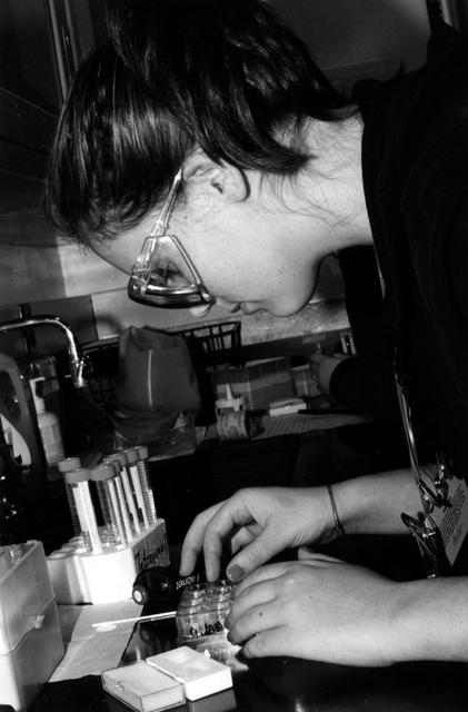High school students screen crystals of various proteins that are part of the ground-based work that supports Alexander McPherson's protein crystal growth experiment. The students also prepared and stored samples in the Enhanced Gaseous Nitrogen Dewar, which was launched on the STS-98 mission for delivery to the ISS. The crystals grown on the ground will be compared with crystals grown in orbit. Participants include Joseph Negron, of Terry Parker High School, Jacksonville, Florida; Megan Miskowski (shown), of Ridgeview High School, Orange Park, Florida; and Sam Swank, of Fletcher High School, Neptune Beach, Florida. The proteins are placed in plastic tubing that is heat-sealed at the ends, then flash-frozen and preserved in a liquid nitrogen Dewar. Aboard the ISS, the nitrogen will be allowed to evaporated so the samples thaw and then slowly crystallize. They will be analyzed after return to Earth. Photo credit: NASA/Marshall Space Flight Center.