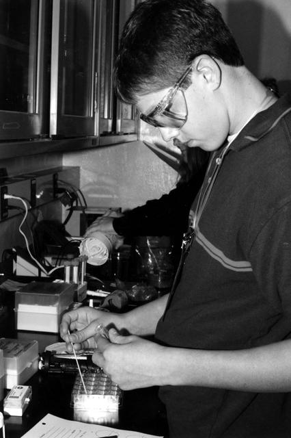 High school students screen crystals of various proteins that are part of the ground-based work that supports Alexander McPherson's protein crystal growth experiment. The students also prepared and stored samples in the Enhanced Gaseous Nitrogen Dewar, which was launched on the STS-98 mission for delivery to the ISS. The crystals grown on the ground will be compared with crystals grown in orbit. Participants include Joseph Negron, of Terry Parker High School, Jacksonville, Florida; Megan Miskowski, of Ridgeview High School, Orange Park, Florida; and Sam Swank (shown), of Fletcher High School, Neptune Beach, Florida. The proteins are placed in plastic tubing that is heat-sealed at the ends, then flash-frozen and preserved in a liquid nitrogen Dewar. Aboard the ISS, the nitrogen will be allowed to evaporated so the samples thaw and then slowly crystallize. They will be analyzed after return to Earth. Photo credit: NASA/Marshall Space Flight Center.