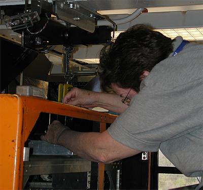 The first NASA Dropping In a Microgravity Environment (DIME) student competition pilot project came to a conclusion at the Glenn Research Center in April 2001. The competition involved high-school student teams who developed the concept for a microgravity experiment and prepared an experiment proposal. The two student teams - COSI Academy, sponsored by the Columbus Center of Science and Industry, and another team from Cincinnati, Ohio's Sycamore High School, designed a microgravity experiment, fabricated the experimental apparatus, and visited NASA Glenn to operate their experiment in the 2.2 Second Drop Tower. Sandi Thompson of the National Center for Microgravity Research GRC makes a final adjustment to the drop package. This image is from a digital still camera; higher resolution is not available.