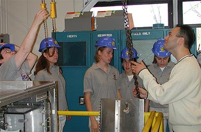 The first NASA Dropping In a Microgravity Environment (DIME) student competition pilot project came to a conclusion at the Glenn Research Center in April 2001. The competition involved high-school student teams who developed the concept for a microgravity experiment and prepared an experiment proposal. The two student teams - COSI Academy, sponsored by the Columbus Center of Science and Industry, and another team from Cincinnati, Ohio's Sycamore High School, designed a microgravity experiment, fabricated the experimental apparatus, and visited NASA Glenn to operate their experiment in the 2.2 Second Drop Tower. Here, students from Sycamore High School in Cincinnati, Ohio, help a NASA technician prepare their experiment. This image is from a digital still camera; higher resolution is not available.